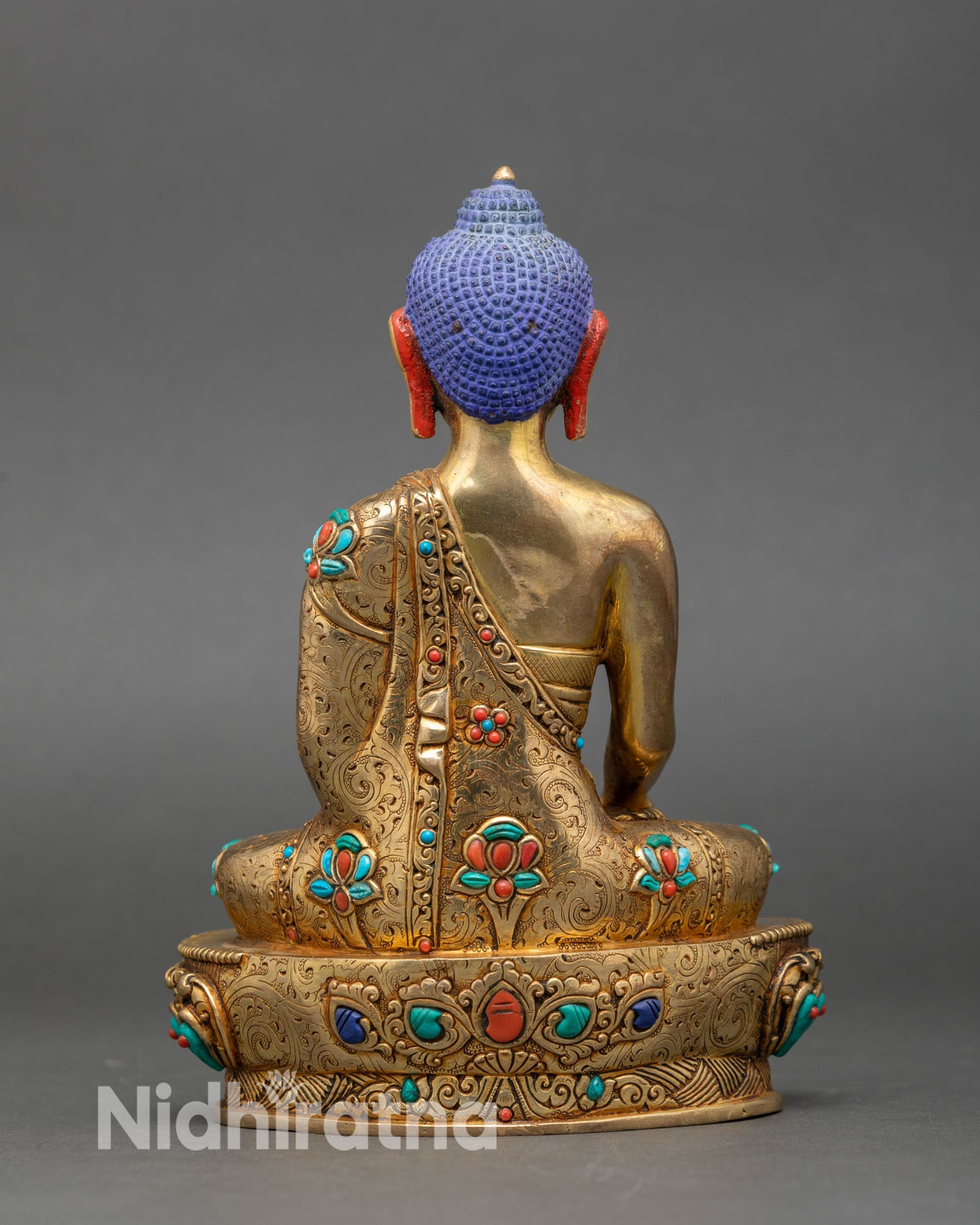 Back view of Shakyamuni Buddha statue ornate robes lotus seat sacred Himalayan artwork