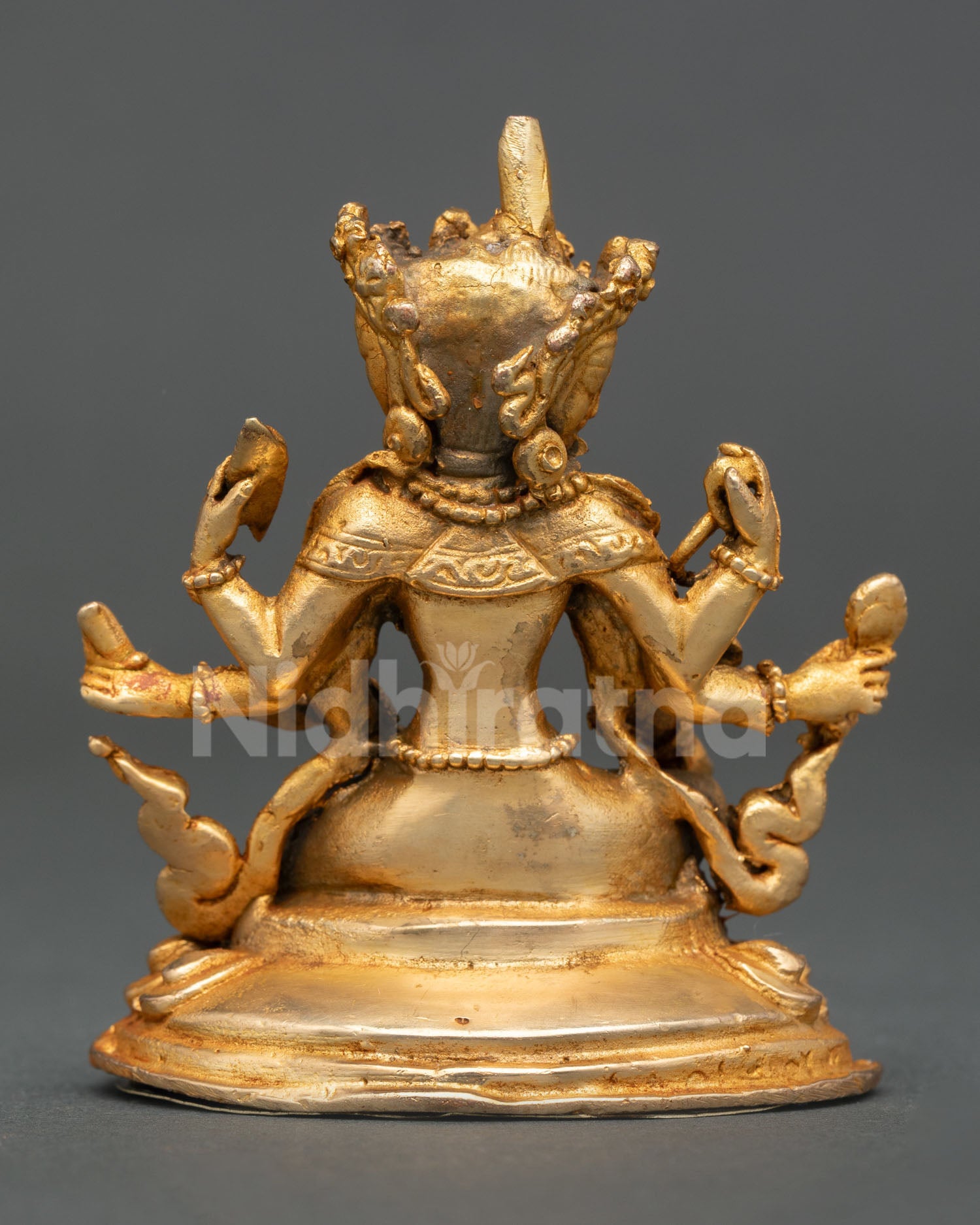 Back view of Vasudhara statue lotus throne gold gilded Nepalese Buddhist art sacred prosperity and wisdom altar sculpture