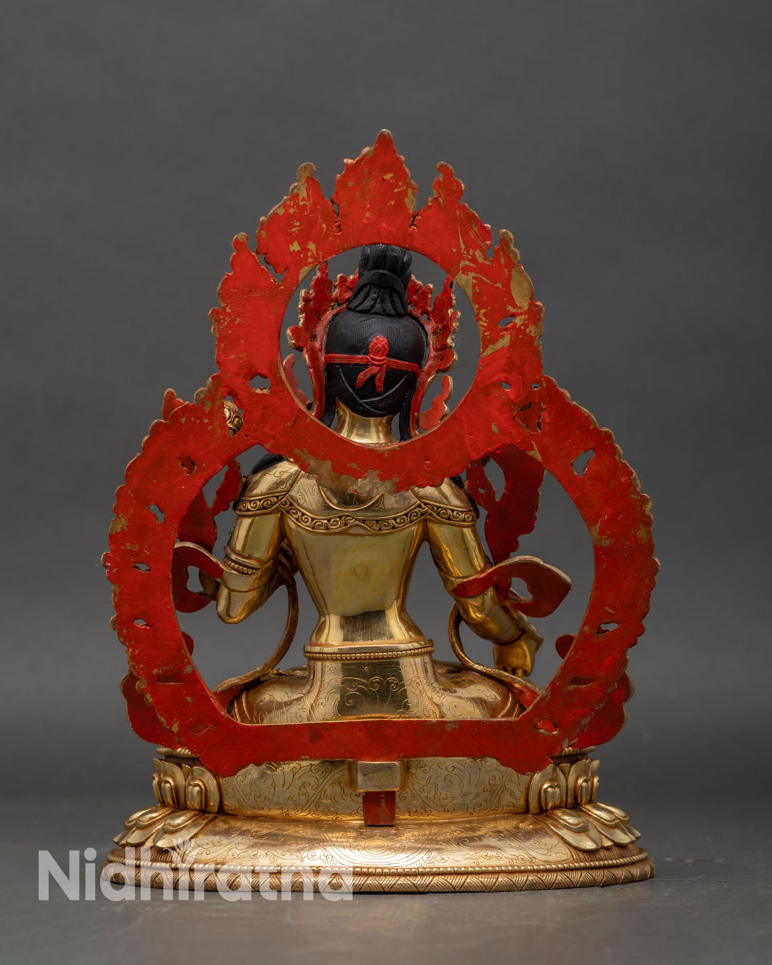 Back view of White Tara statue, engraved lotus base and halo details