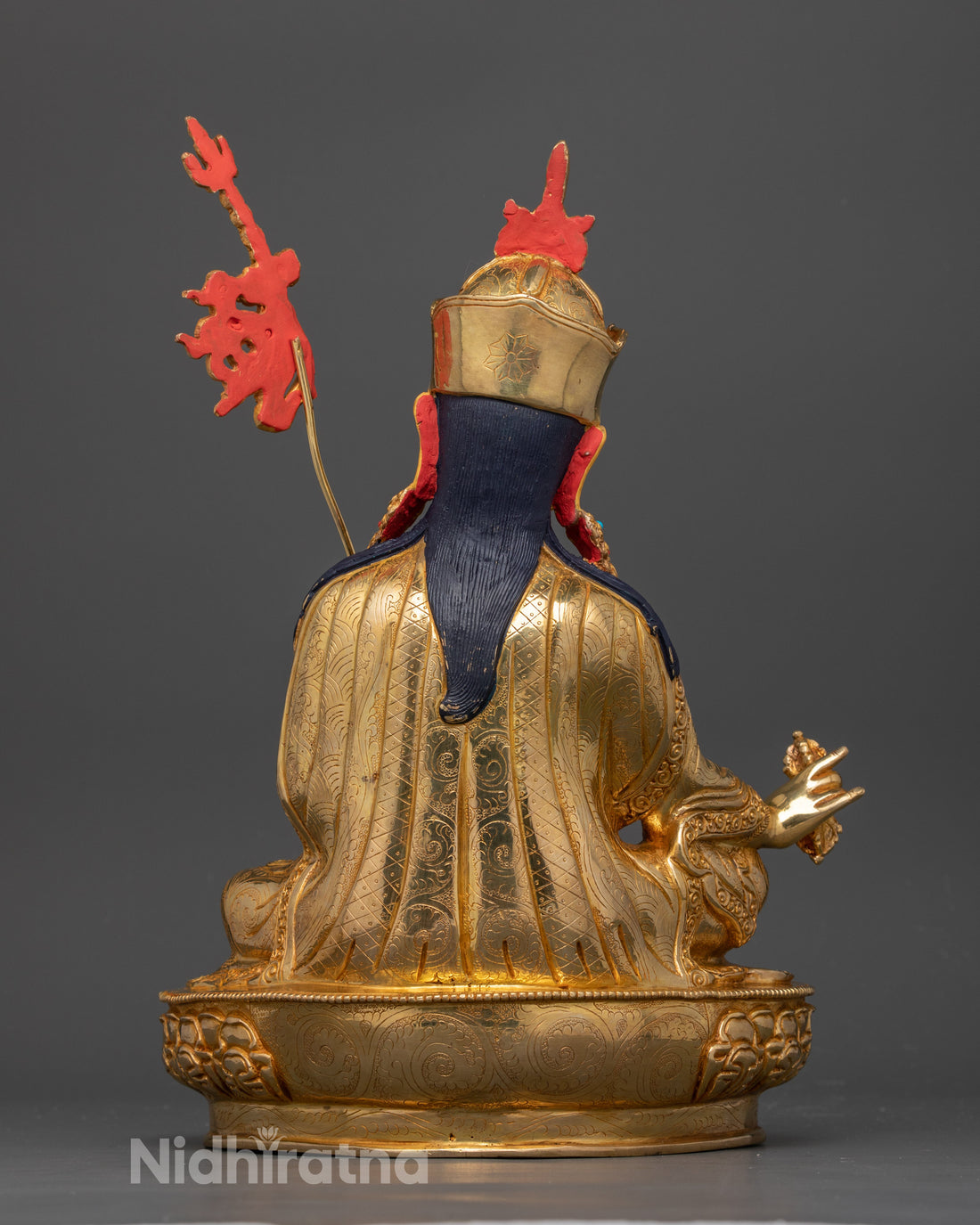 back side of gold plated guru rinpoche statue with black acrylic color used for hair