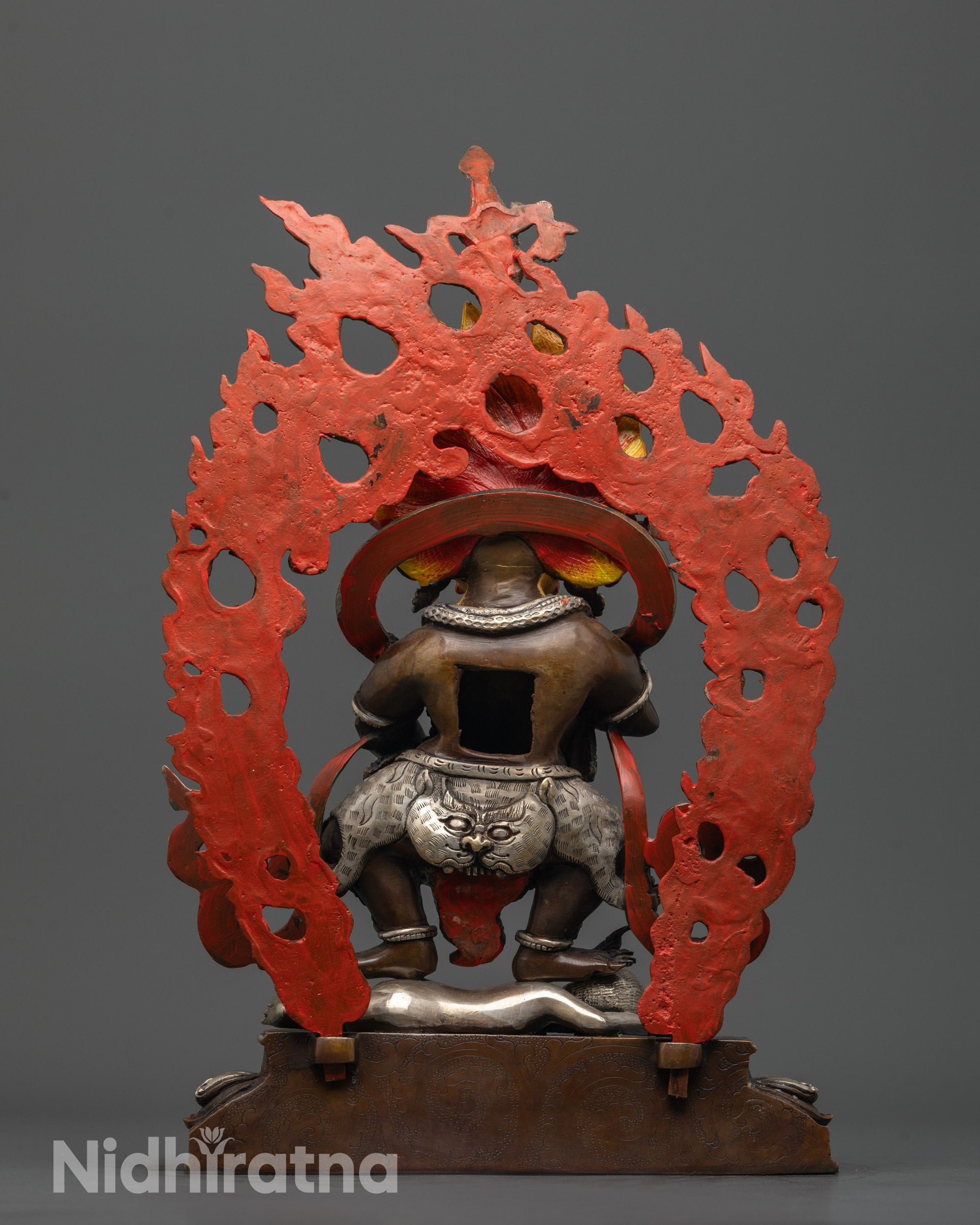 back view Sakya Mahakala statue highlighting silver-plated halo with carved deities and animals