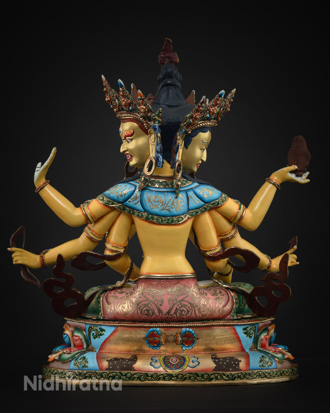 back view of golden namgyalma statue with blue and red accents