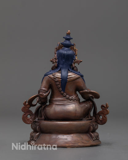 back view of Dzambhala statue highlighting sacred carvings and aged oxidized texture