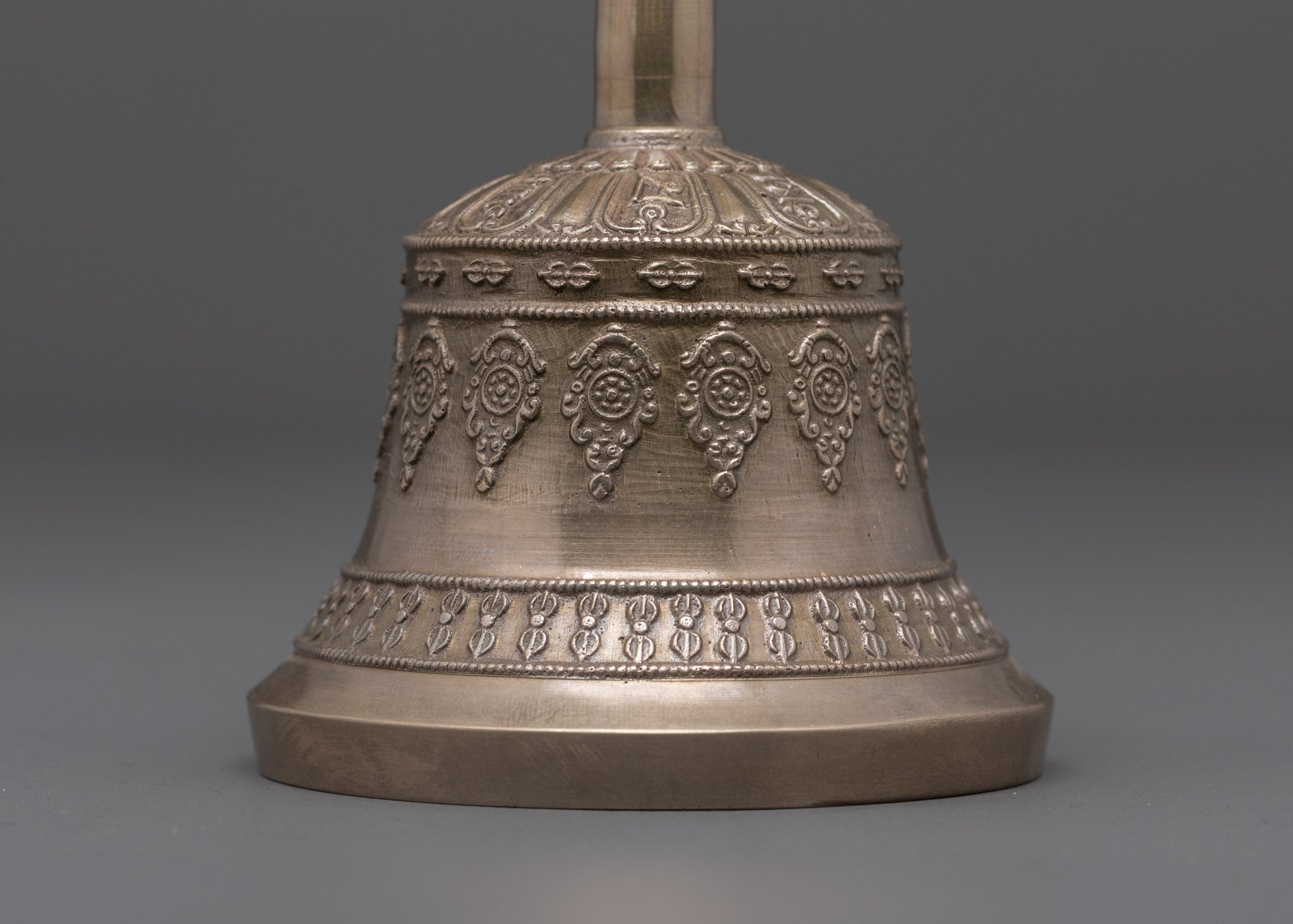 back view of bell highlighting bronze bell body and ornate carved details