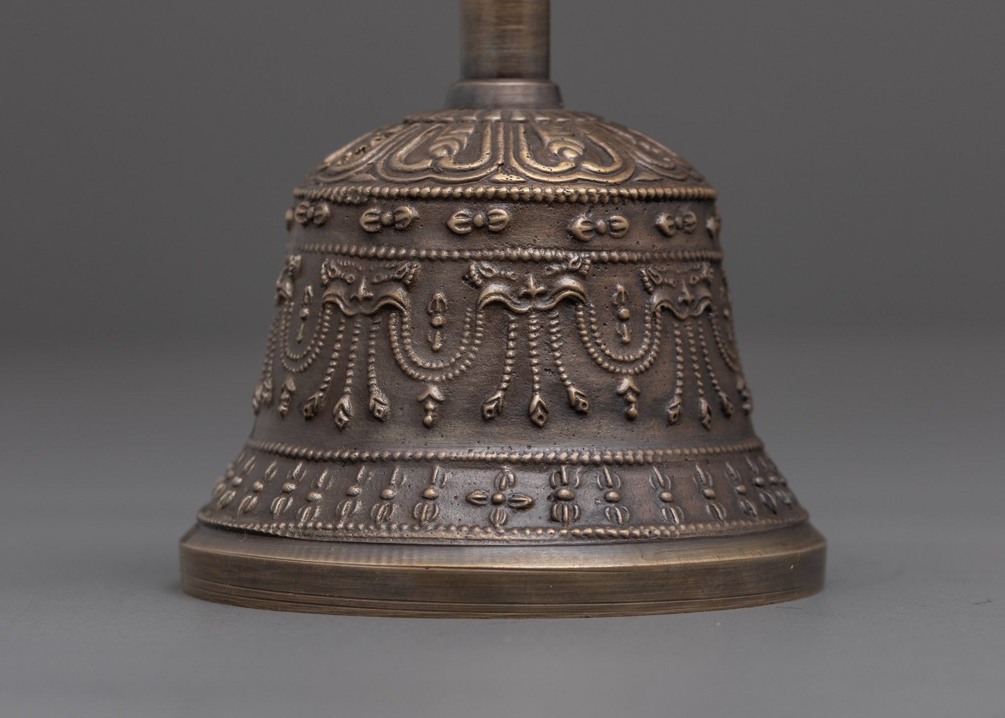 back view of bronze bell set with brass handle deity and artisan craftsmanship