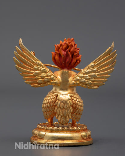 back view of gold-plated garuda statue with detailed feathers and wing structure