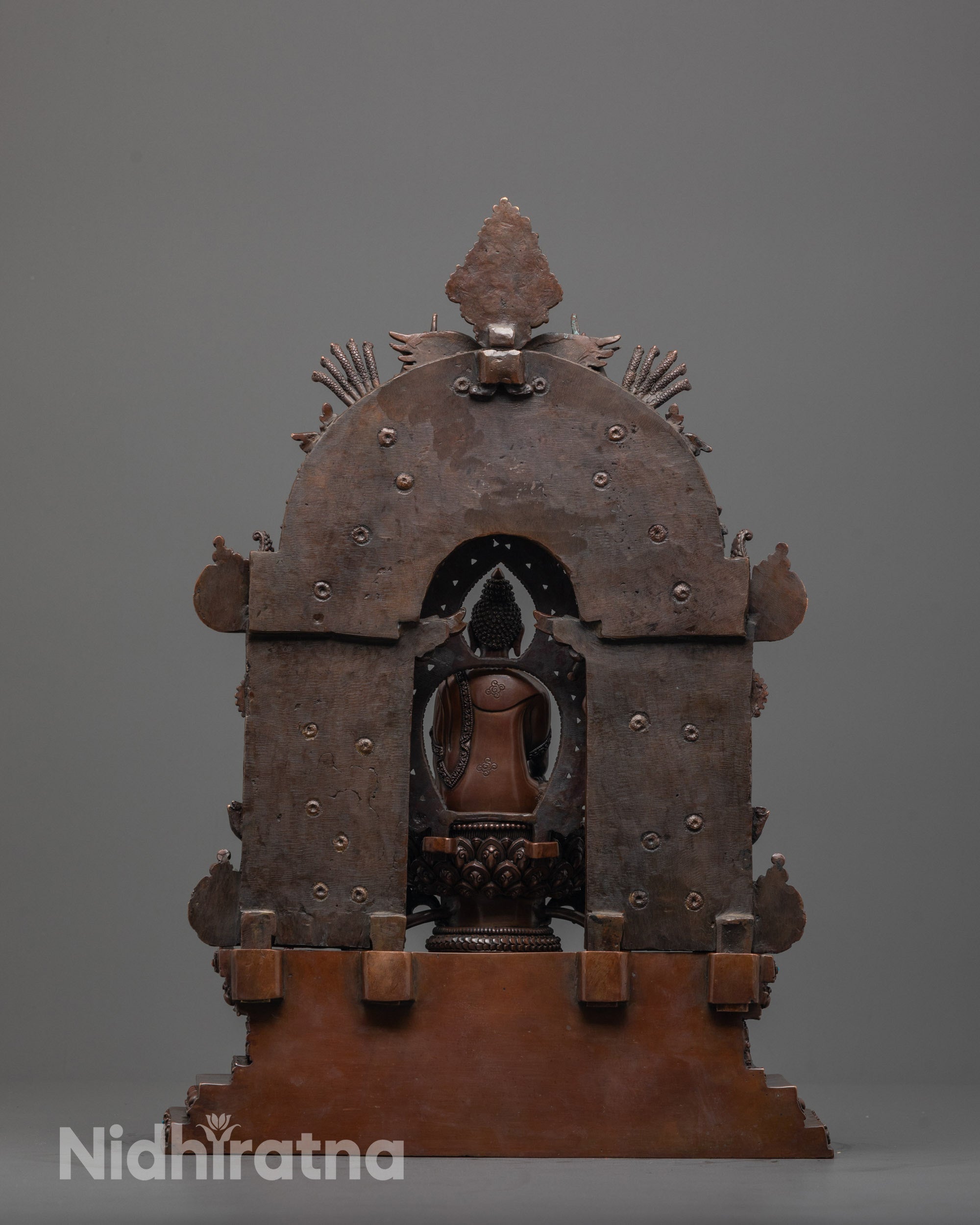 back view of oxidized buddhist sculpture showing throne base and detailed back halo design