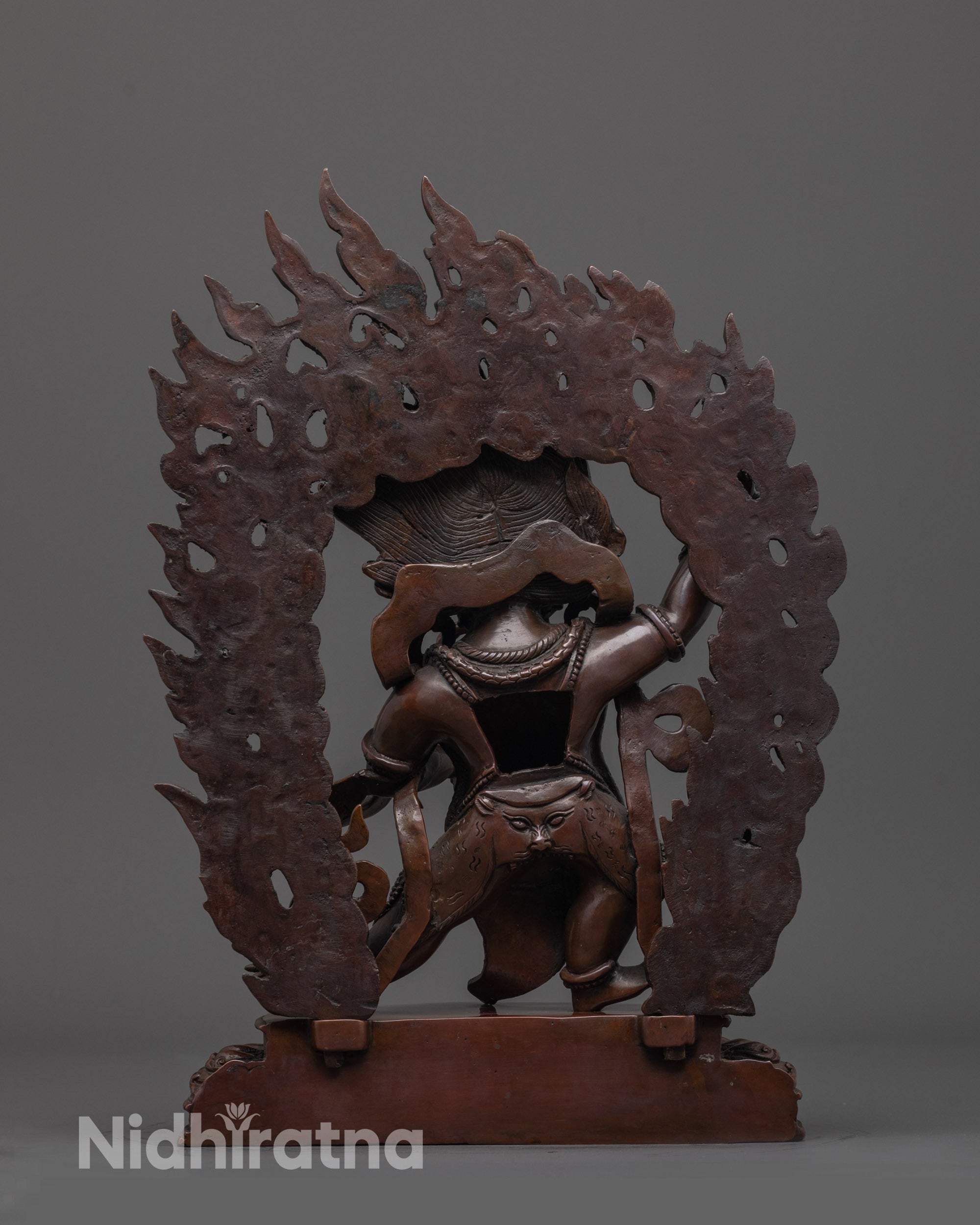 back view of oxidized vajrapani statue highlighting oxidized copper texture and halo detailing