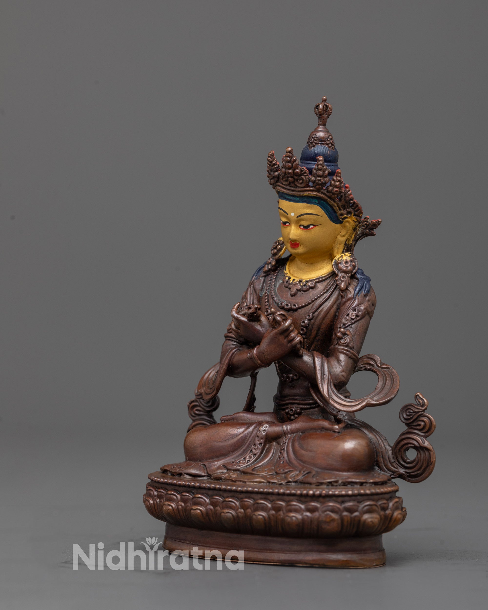 back view of vajradhara statue with oxidized copper body and detailed robe