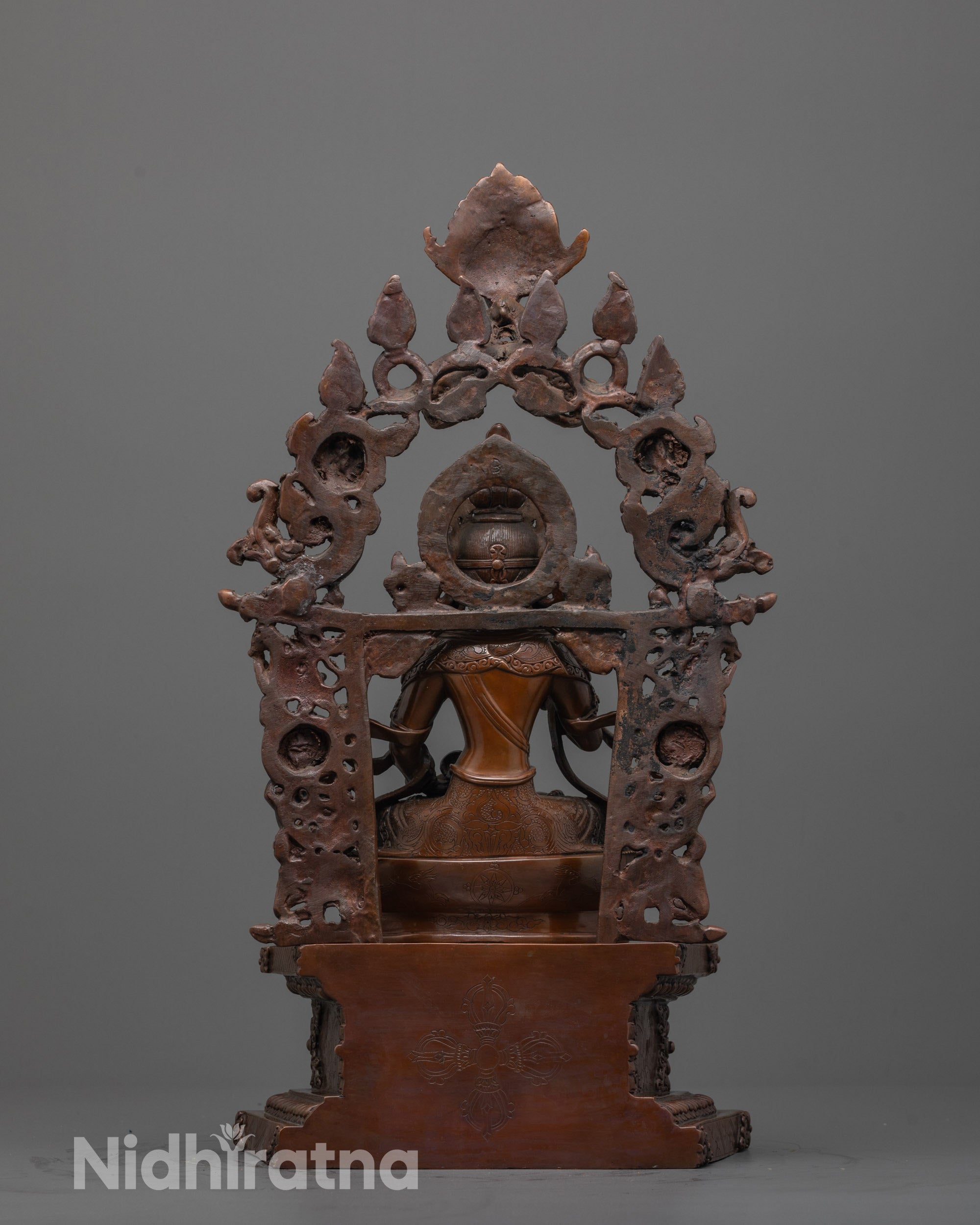 back view of vajrasattva statue featuring vishva vajra and deities carved on the grand halo