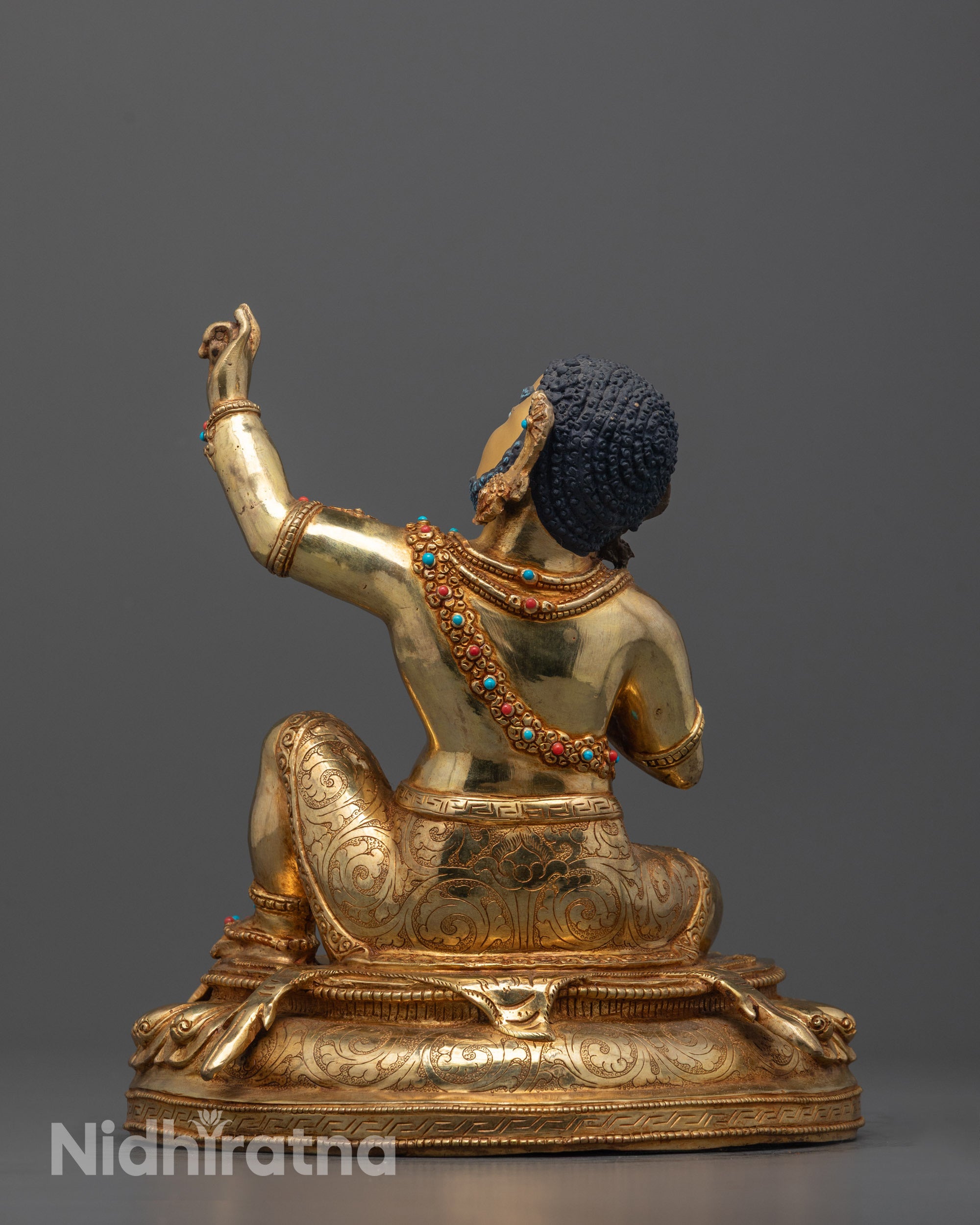 back view of virupa statue with deer skin carving and detailed fire-gilded robe
