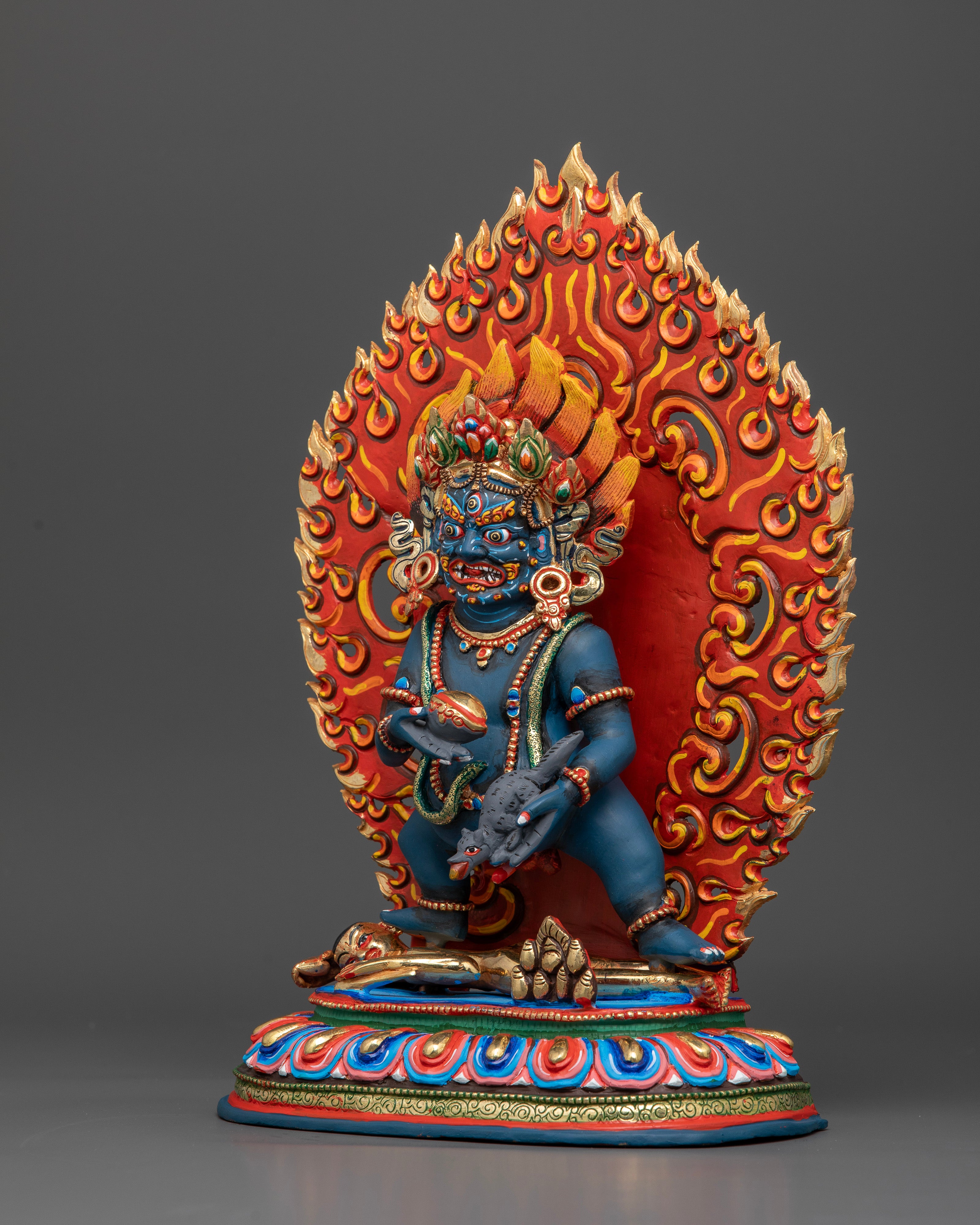 Black Dzambhala standing on colorful lotus pedestal with fiery halo.