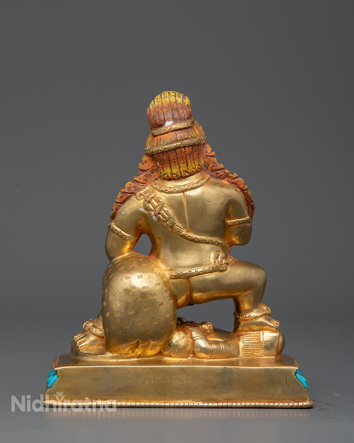 Black Dzambhala holding skull cup and treasure spitting mongoose.