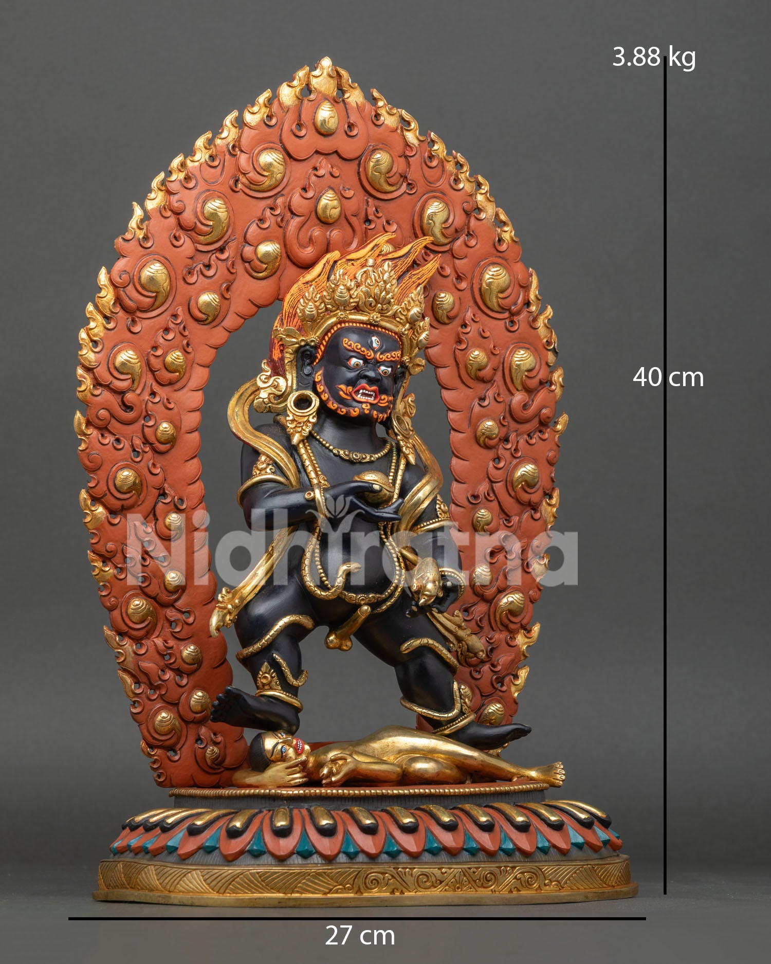 Black Dzambhala statue on lotus pedestal, holding kapala and mongoose, symbol of prosperity