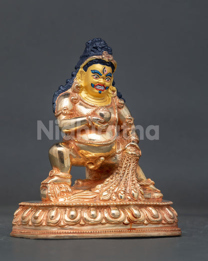 Black dzambhala statue seated on lotus base with raised leg and wrathful protective expression.