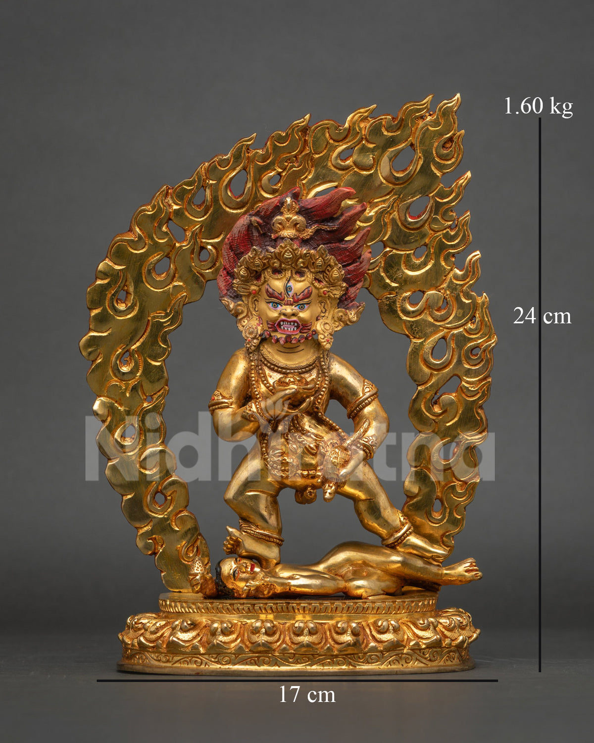 Black dzambhala statue standing on lotus pedestal with flaming halo and mongoose.
