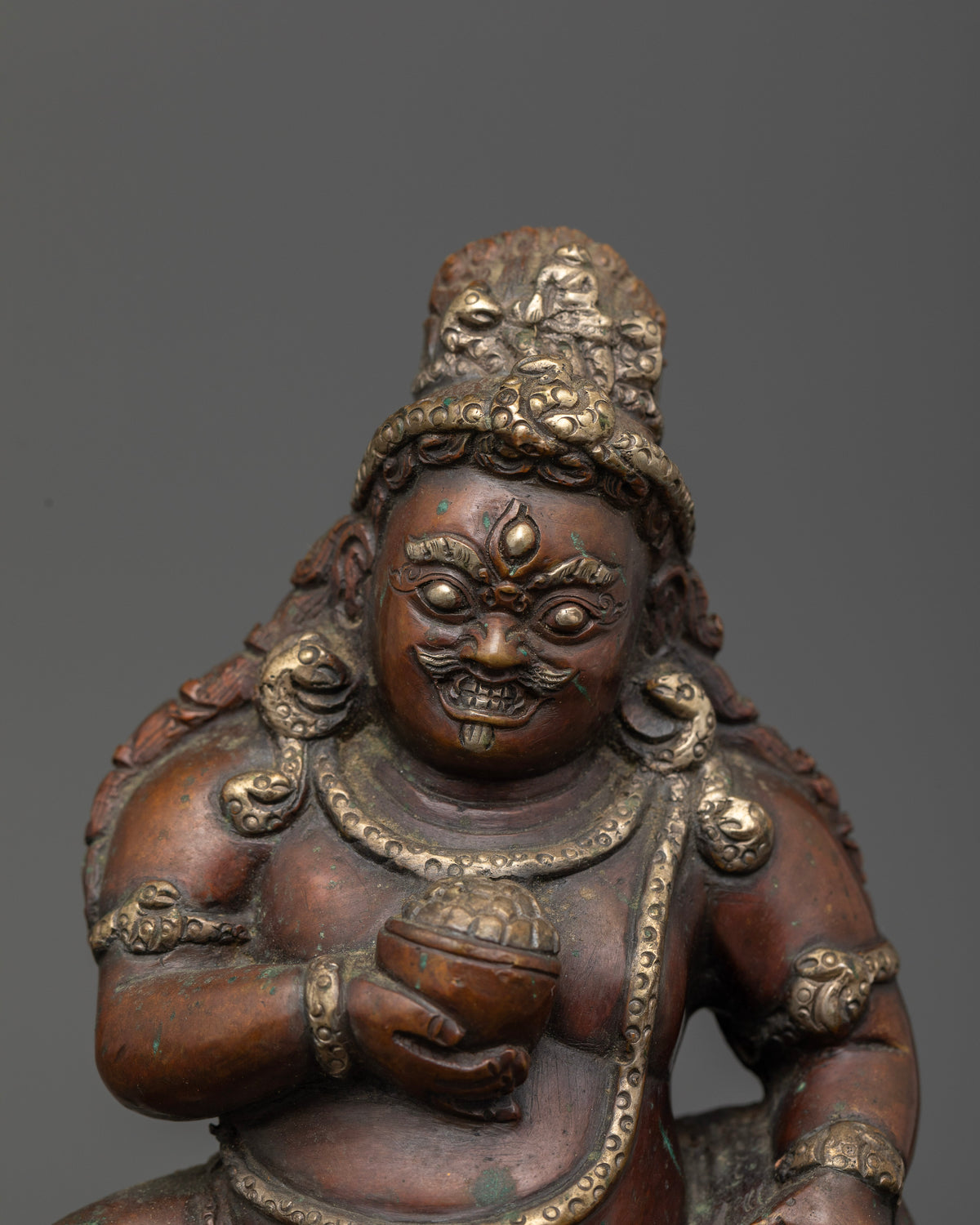 Black Dzambhala with fierce third eye standing on lotus base.