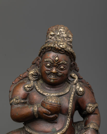 Black Dzambhala with fierce third eye standing on lotus base.