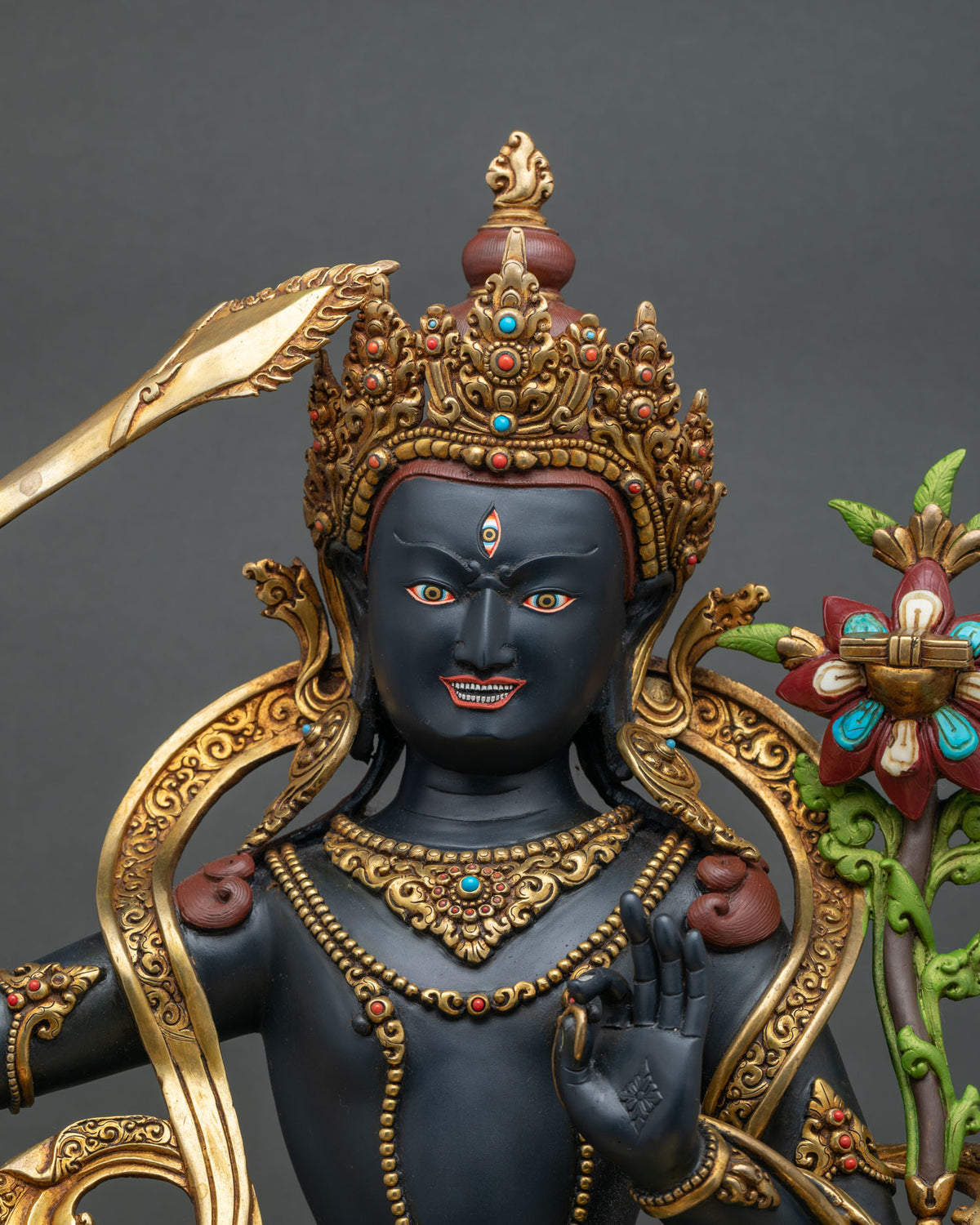 Black Manjushri statue upper body close-up with five-point crown, third eye and Vitarka mudra hand