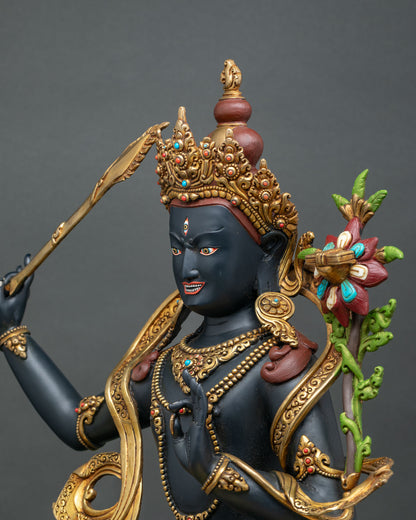 Black Manjushri statue wielding flaming sword of wisdom and holding lotus with Prajnaparamita Sutra