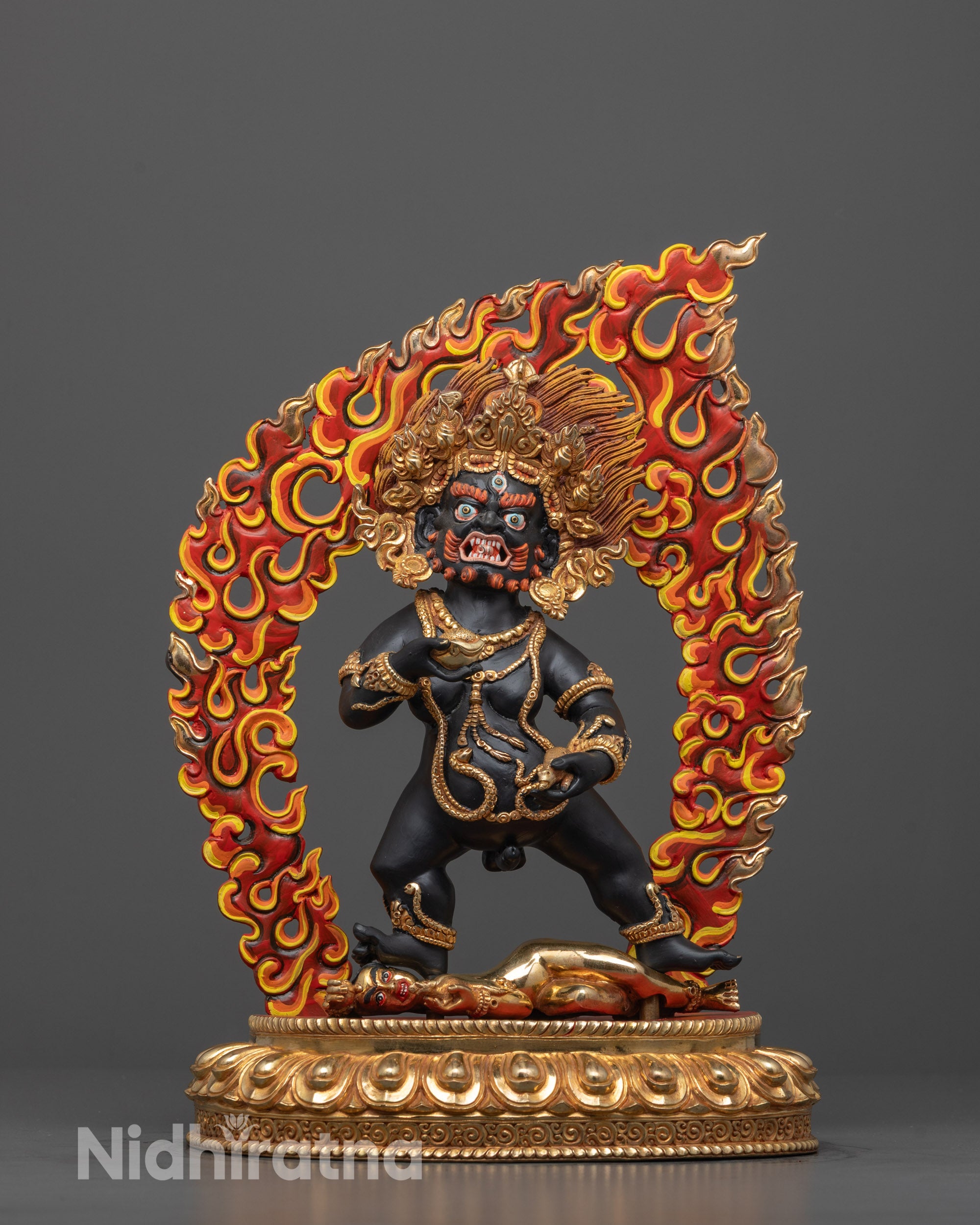 black dzambhala statue front view with gold-plated details and wrathful expression