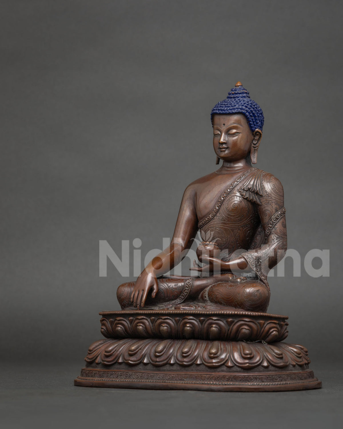 Buddha seated on a hand carved double lotus pedestal in earth touching mudra