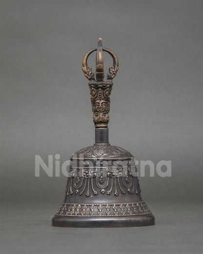 Buddhist bronze bell with brass handle featuring a beautifully carved deity