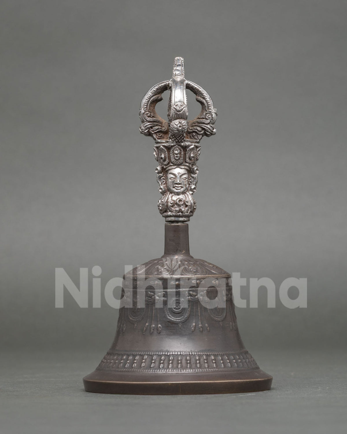 Buddhist ritual bell with brass handle and intricate carved deity