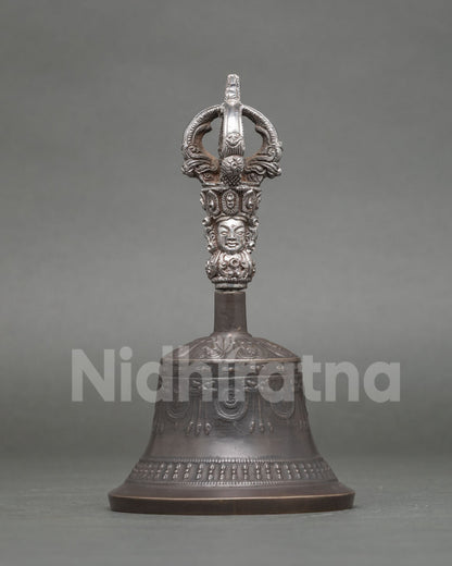 Buddhist ritual bell with brass handle and intricate carved deity
