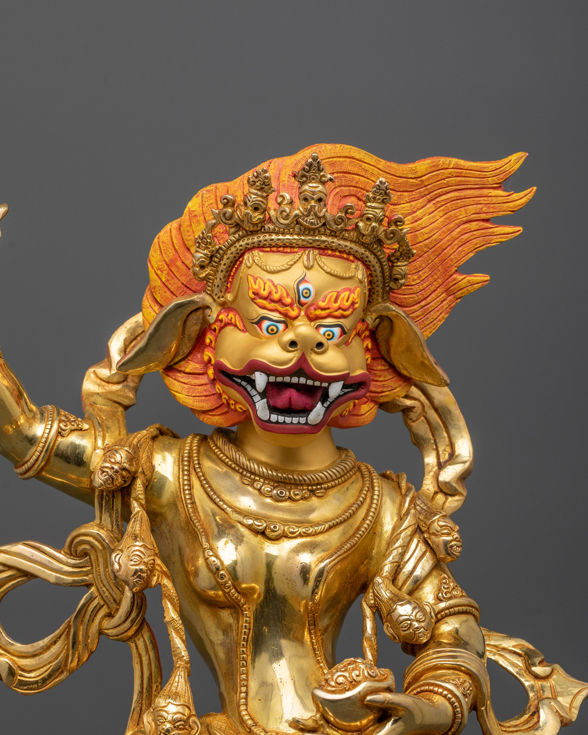 Close-up of Singha Mukha’s lion-like wrathful face with gold-gilded finish