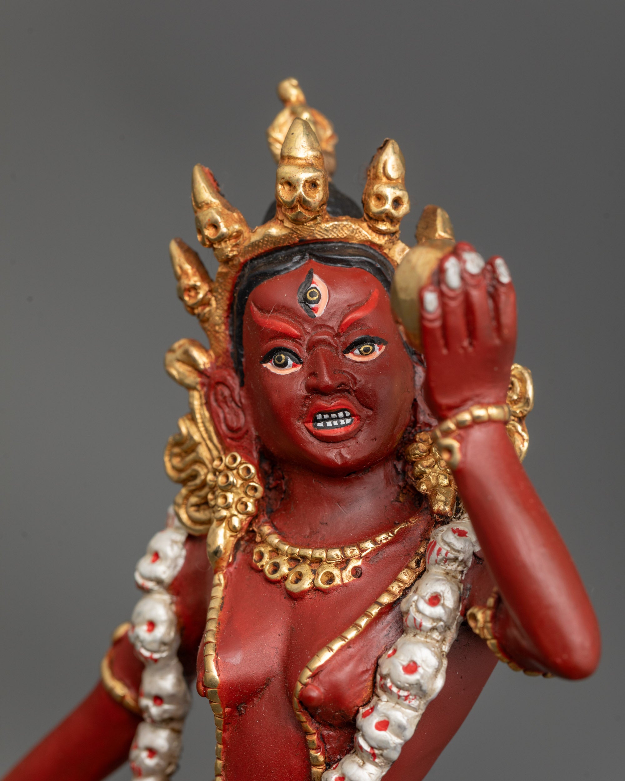 Close up of Vajrayogini face highlighting third eye, five-skull crown, and vivid red colors