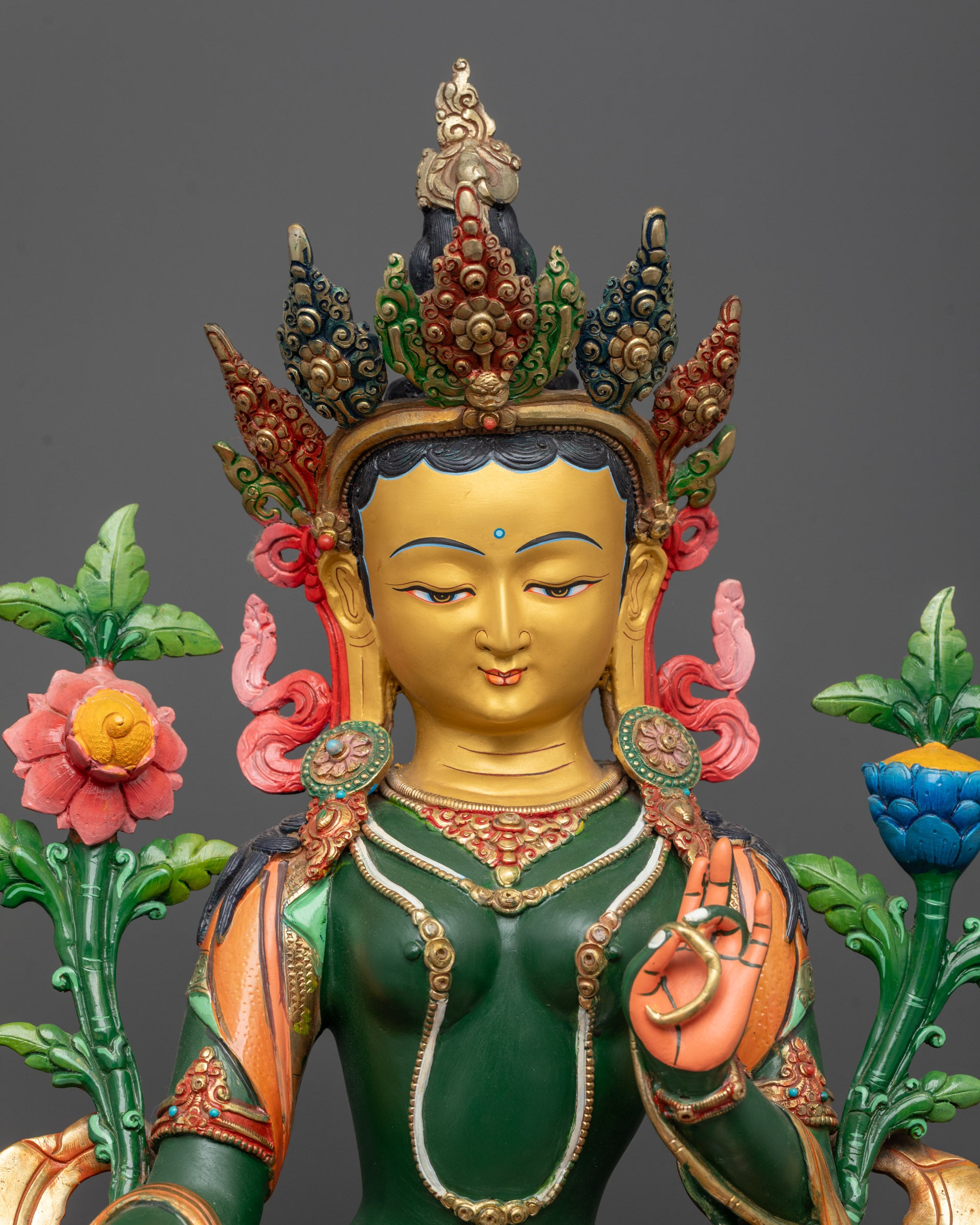 Close up of Green Tara sculpture showing five-jeweled crown and utpala flower