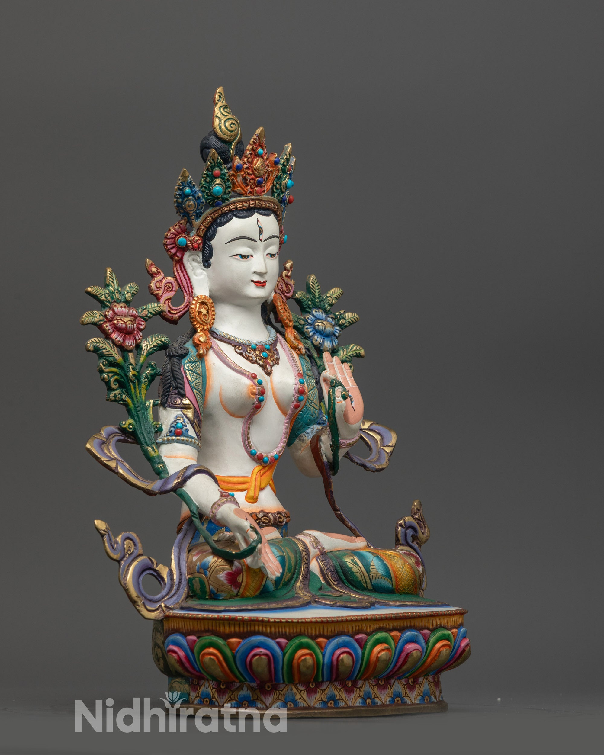 Side view of White Tara statue highlighting floating robe and utpala flower
