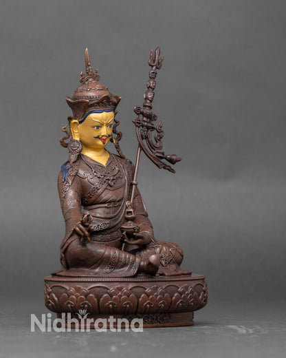 Side view Guru Rinpoche holding vajra and skull cup seated on lotus pedestal
