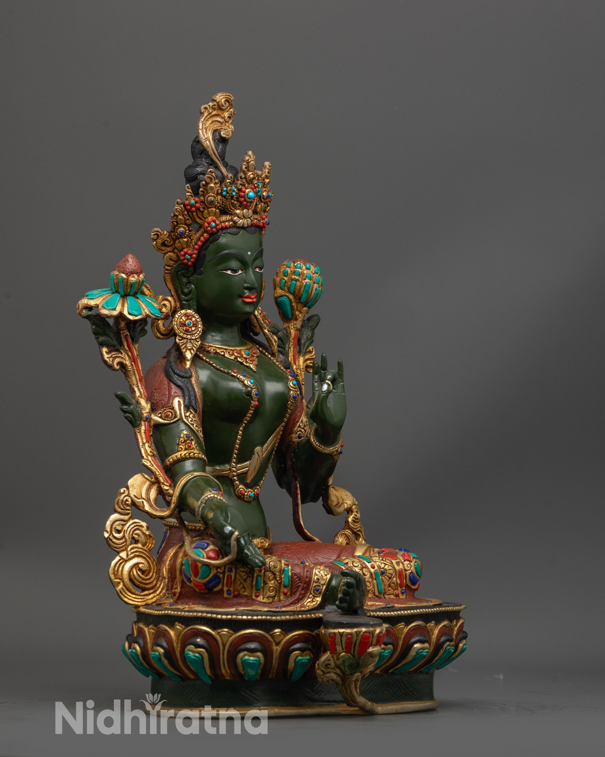 Side view of green-hued Arya Tara Statue seated on gold-plated lotus and semi-precious stones