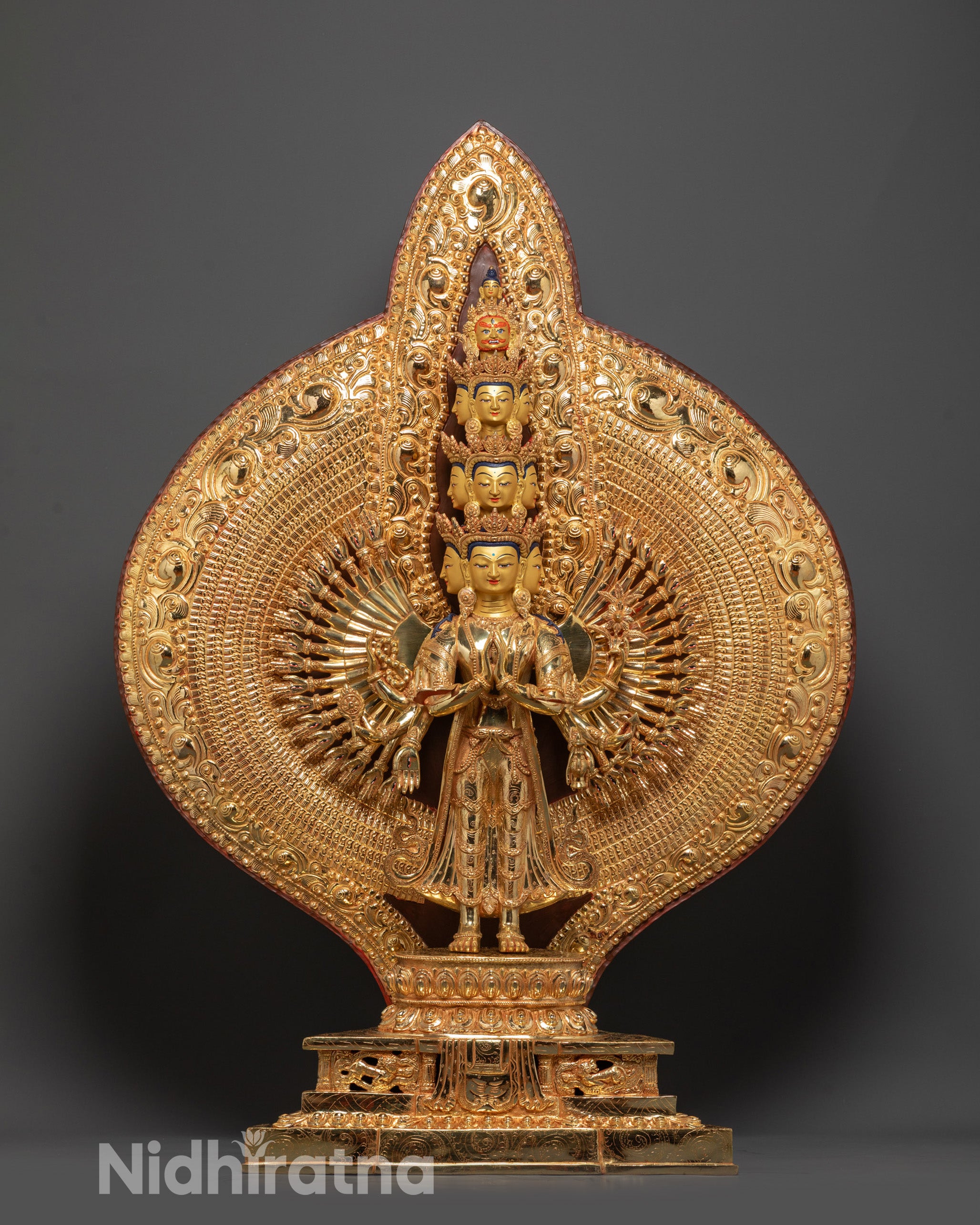 Front view of Thousand-Armed Avalokiteshvara statue with gold-gilded face and detailed arms