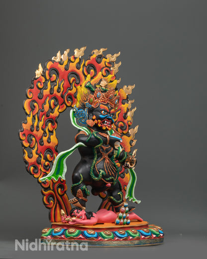 Side angle Black Dzambhala sculpture with black body and flowing green robe on lotus

