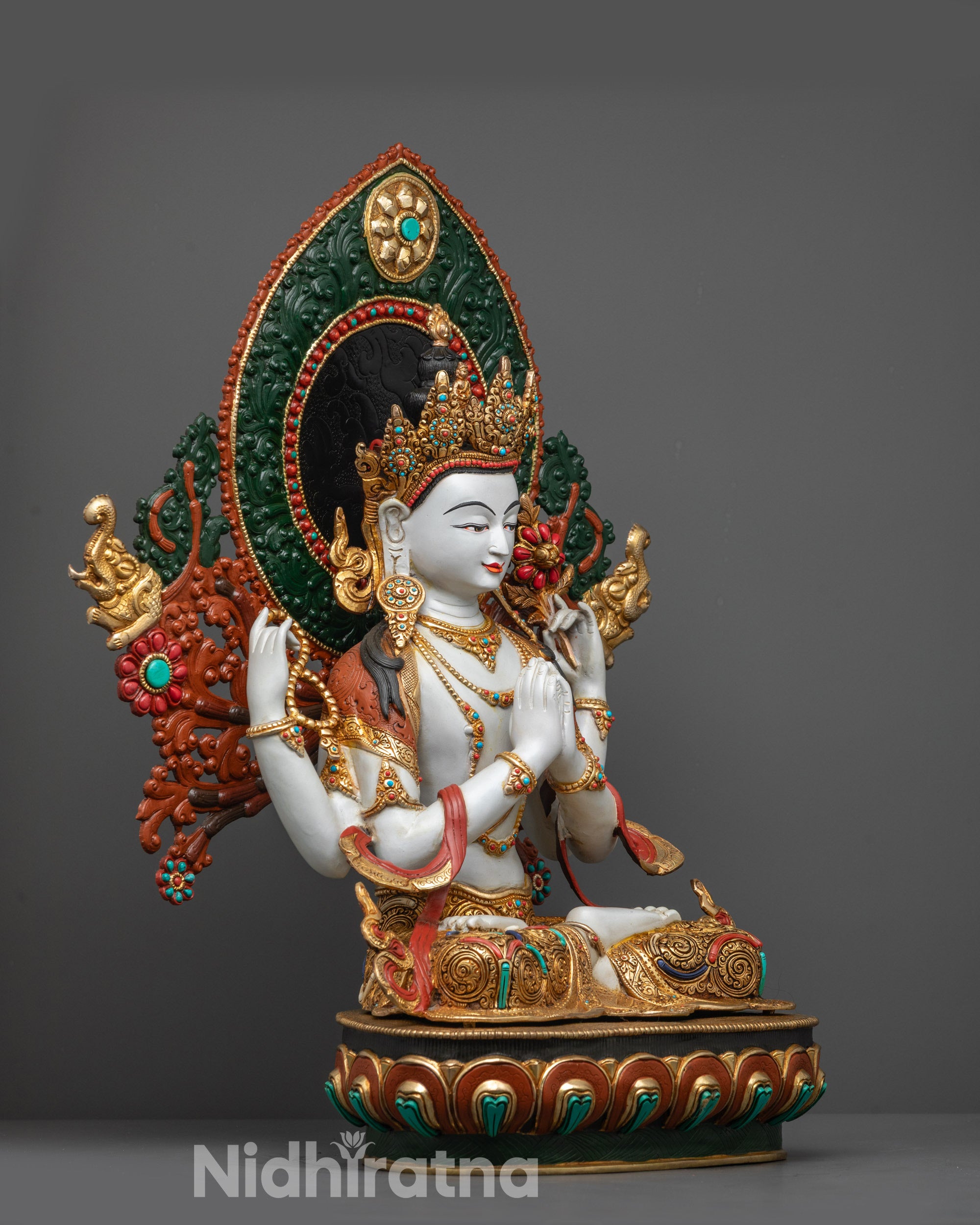 Side view of Tibetan Chenrezig Statue highlighting four arms and sacred objects
