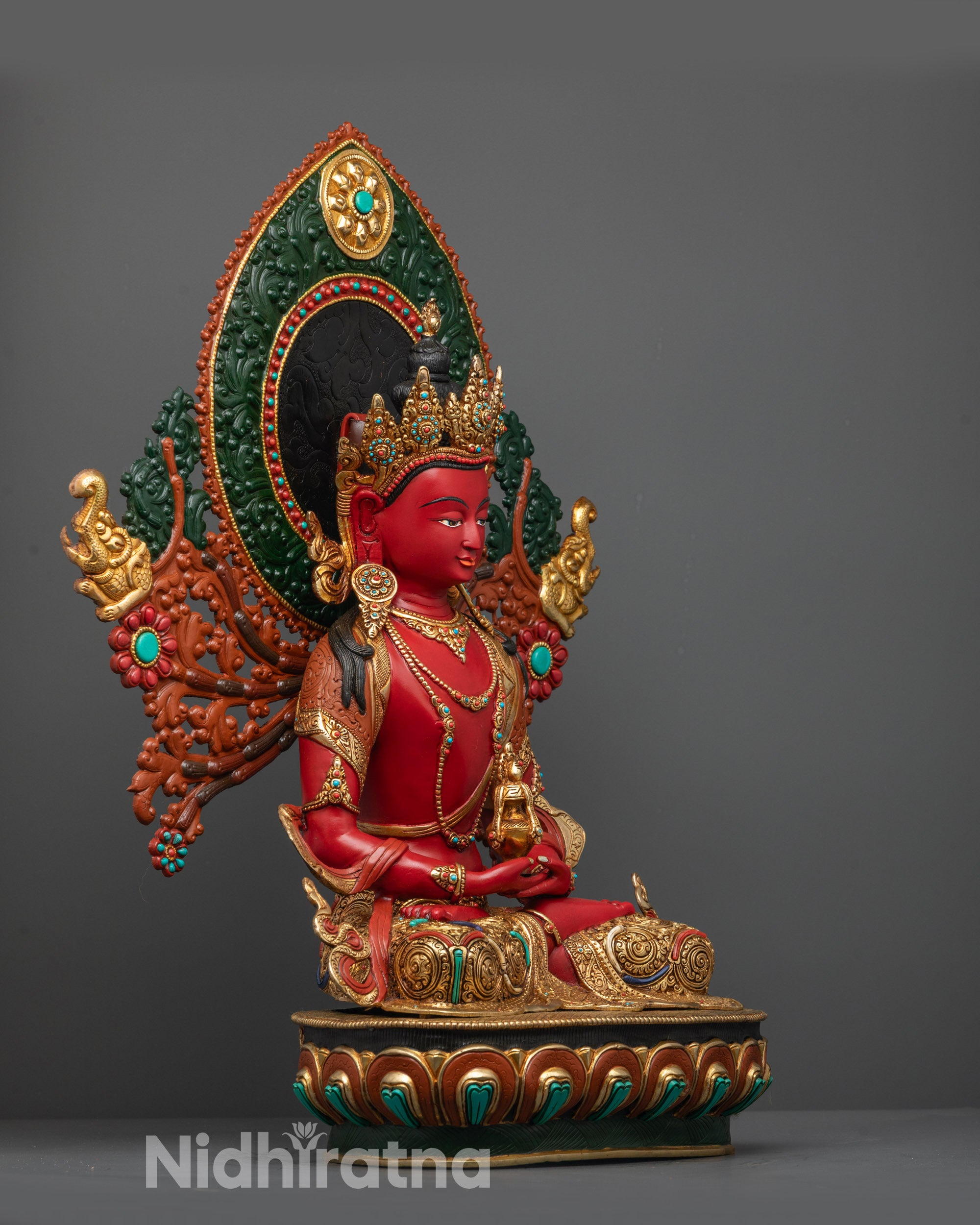 Side view of Red Hued Amitayus Statue displaying garments, intricate carvings, and halo