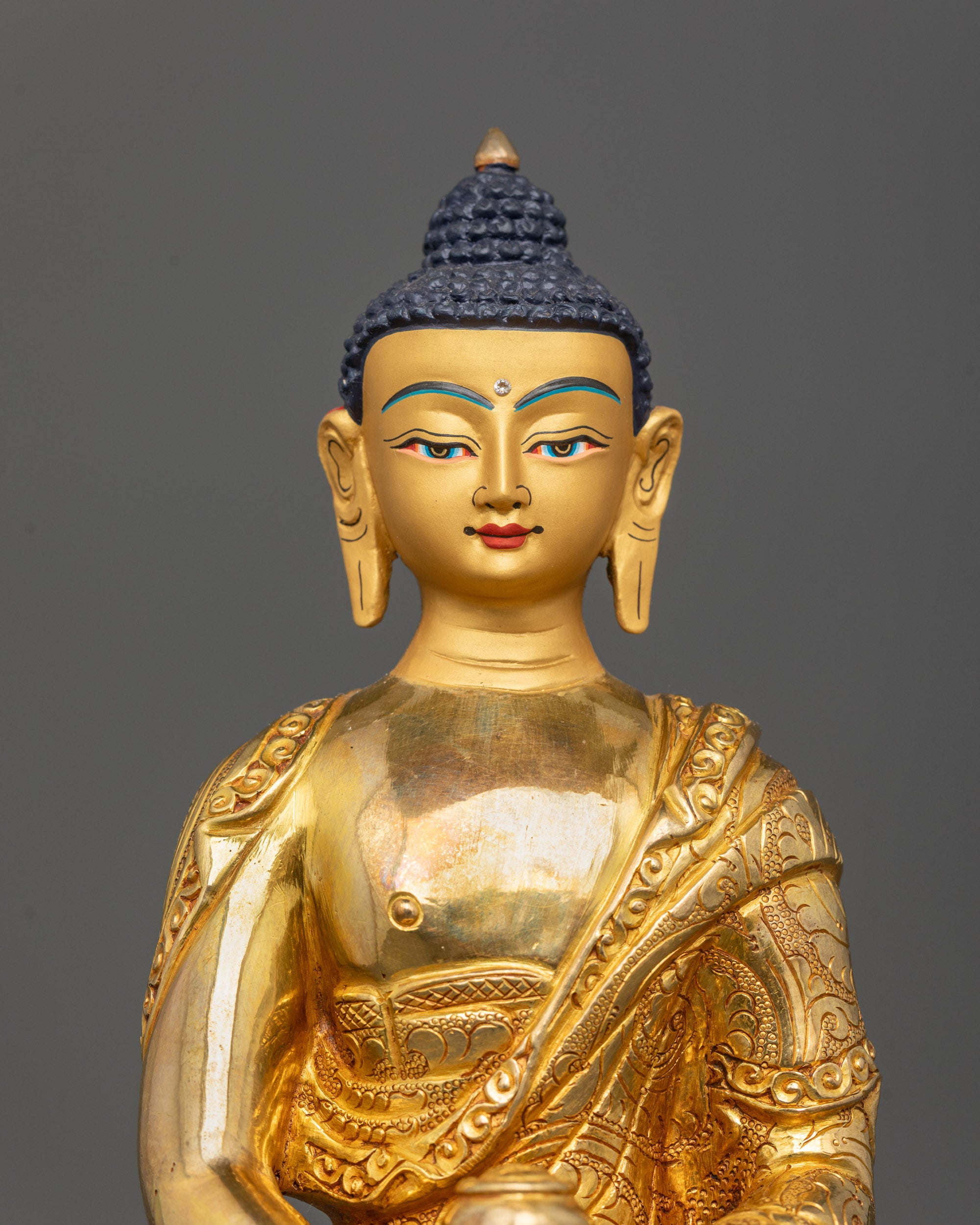 Close-up of Amitabha Buddha Statue’s peaceful face with radiant 24k gold finish