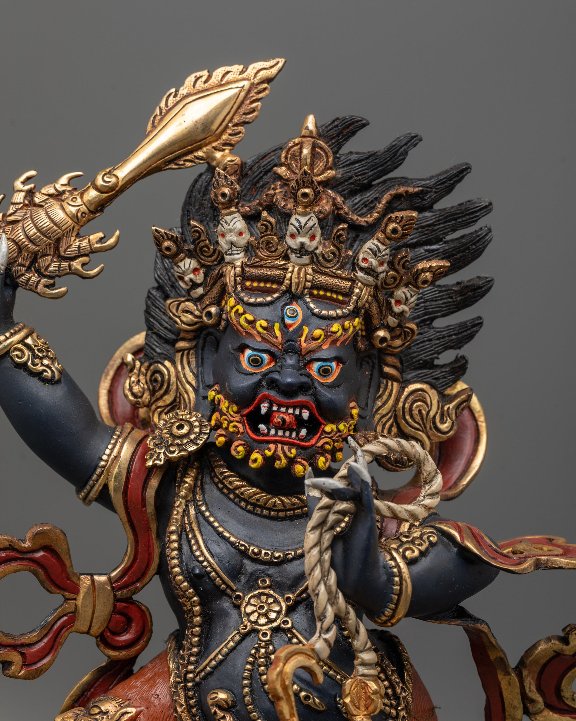 Close-up of wrathful face and sword of Nepalese Sankata Statue with fiery halo