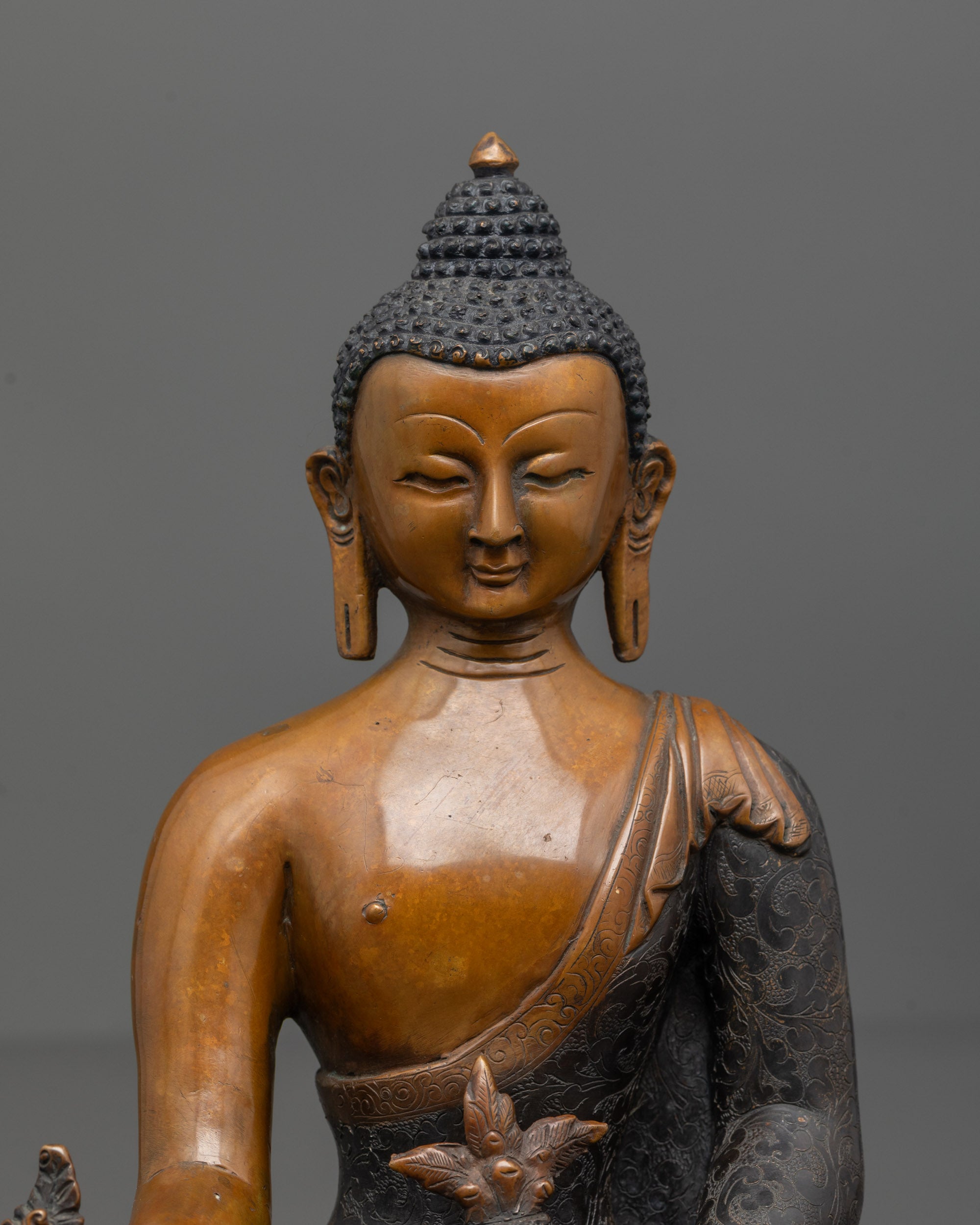 Close-up of oxidized copper texture and acrylic finish on Medicine Buddha statue