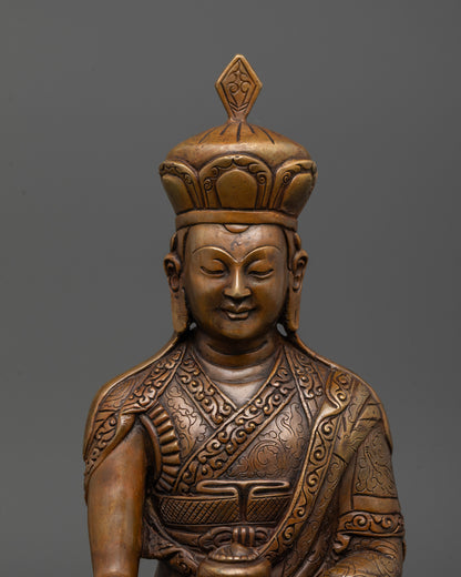 close-up of oxidized karmapa statue showing alms bowl and intricate facial details

