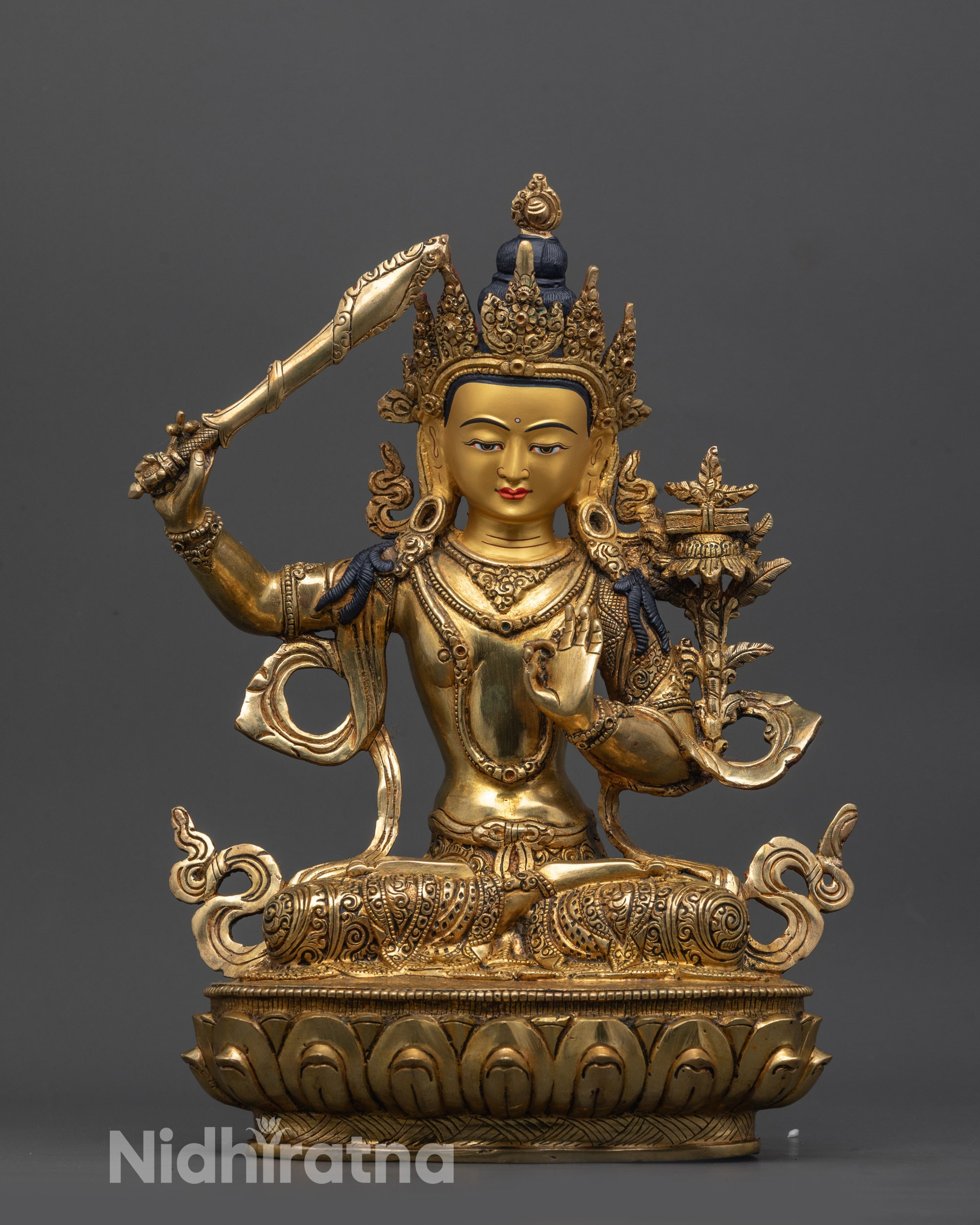 Front view of Monju Bosatsu statue with flaming sword and lotus base, gold-gilded face
