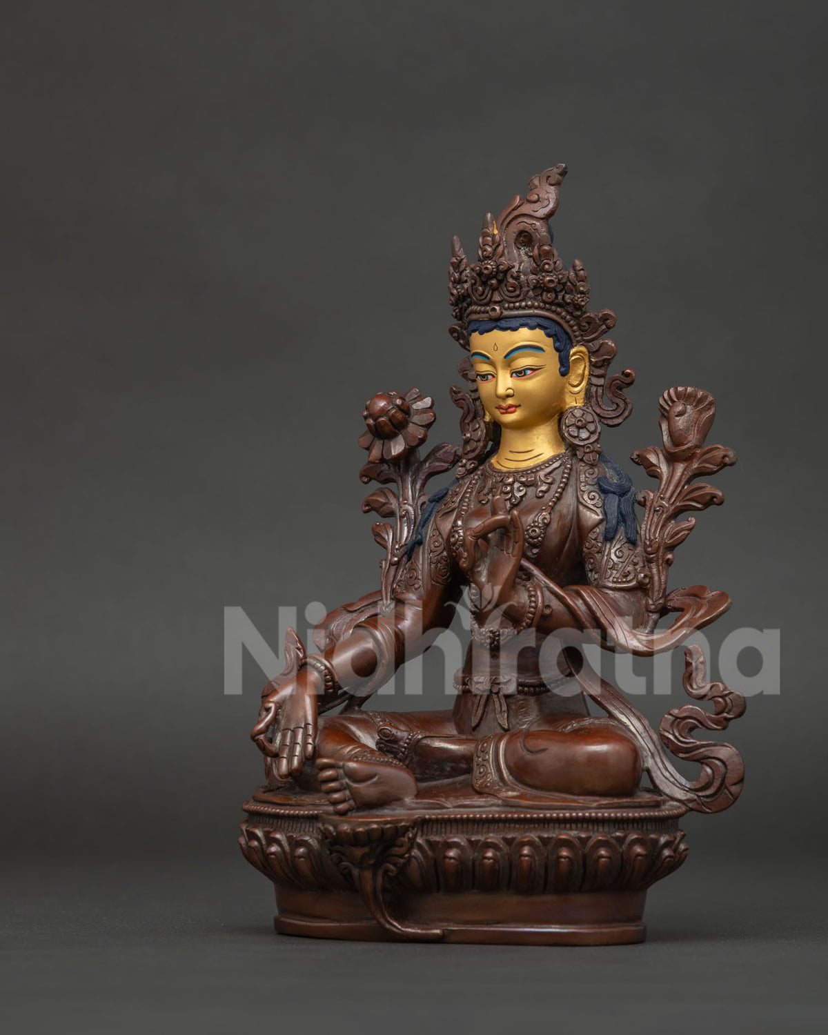 Chemically oxidized Green Tara statue with 24k gold painted face and lotus pedestal.