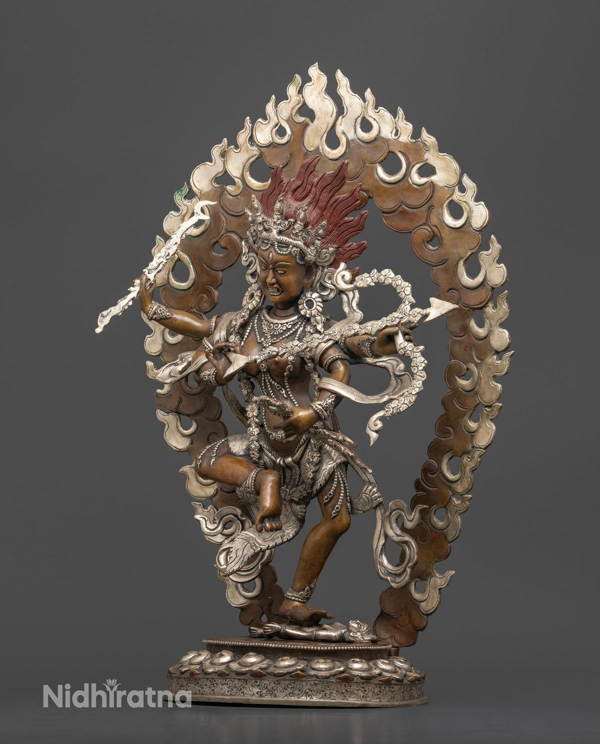 Chemically oxidized Kurukulla statue standing on a human figure with detailed silver plated accents.