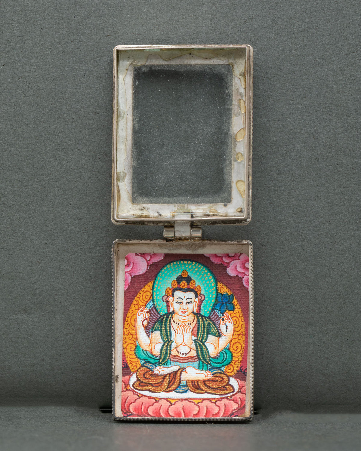 Chenrezig locket miniature four armed thangka hand painted with gold pigments.