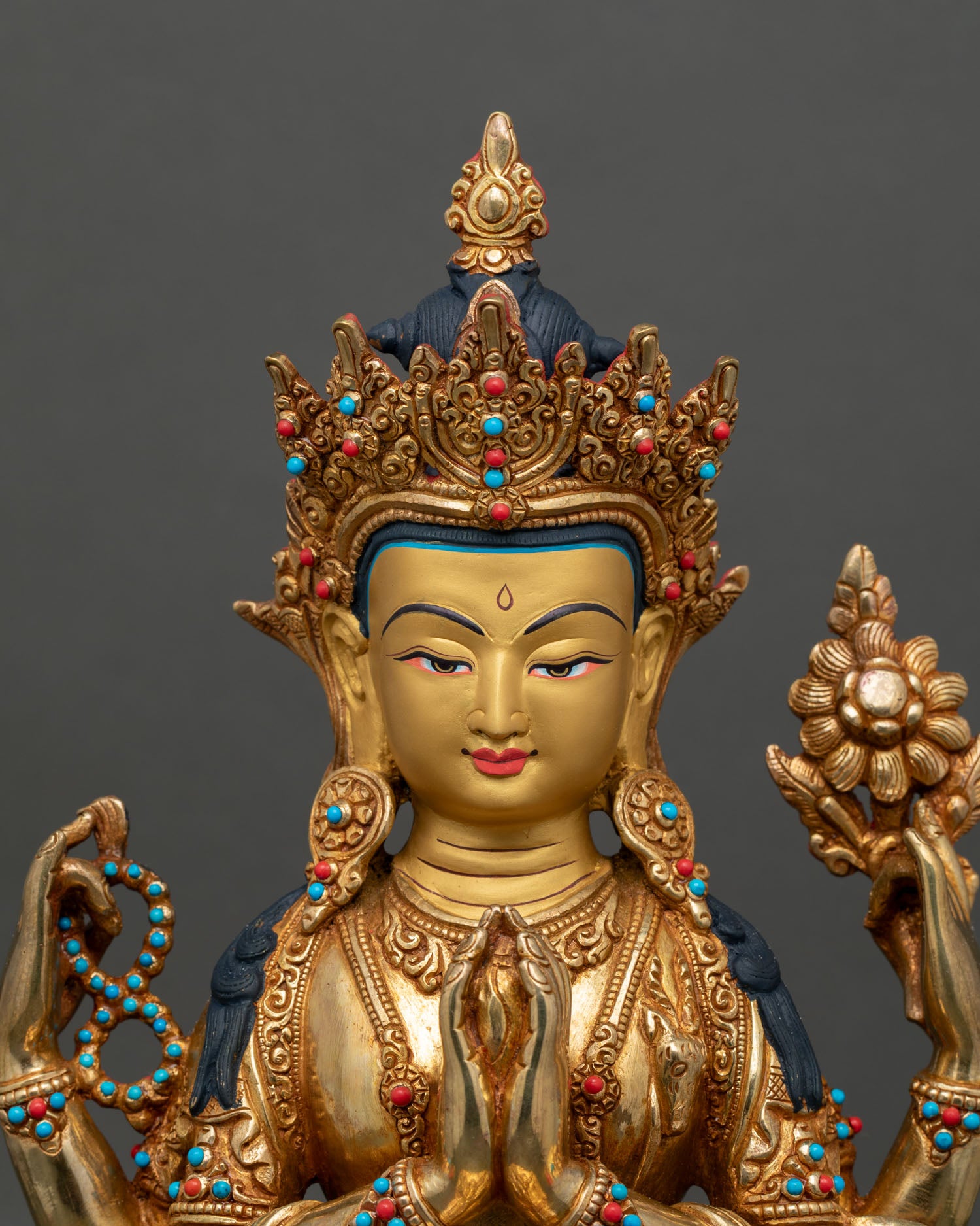 Chenrezig statue close up hands joined at heart serene face gold details himalayan craftsmanship