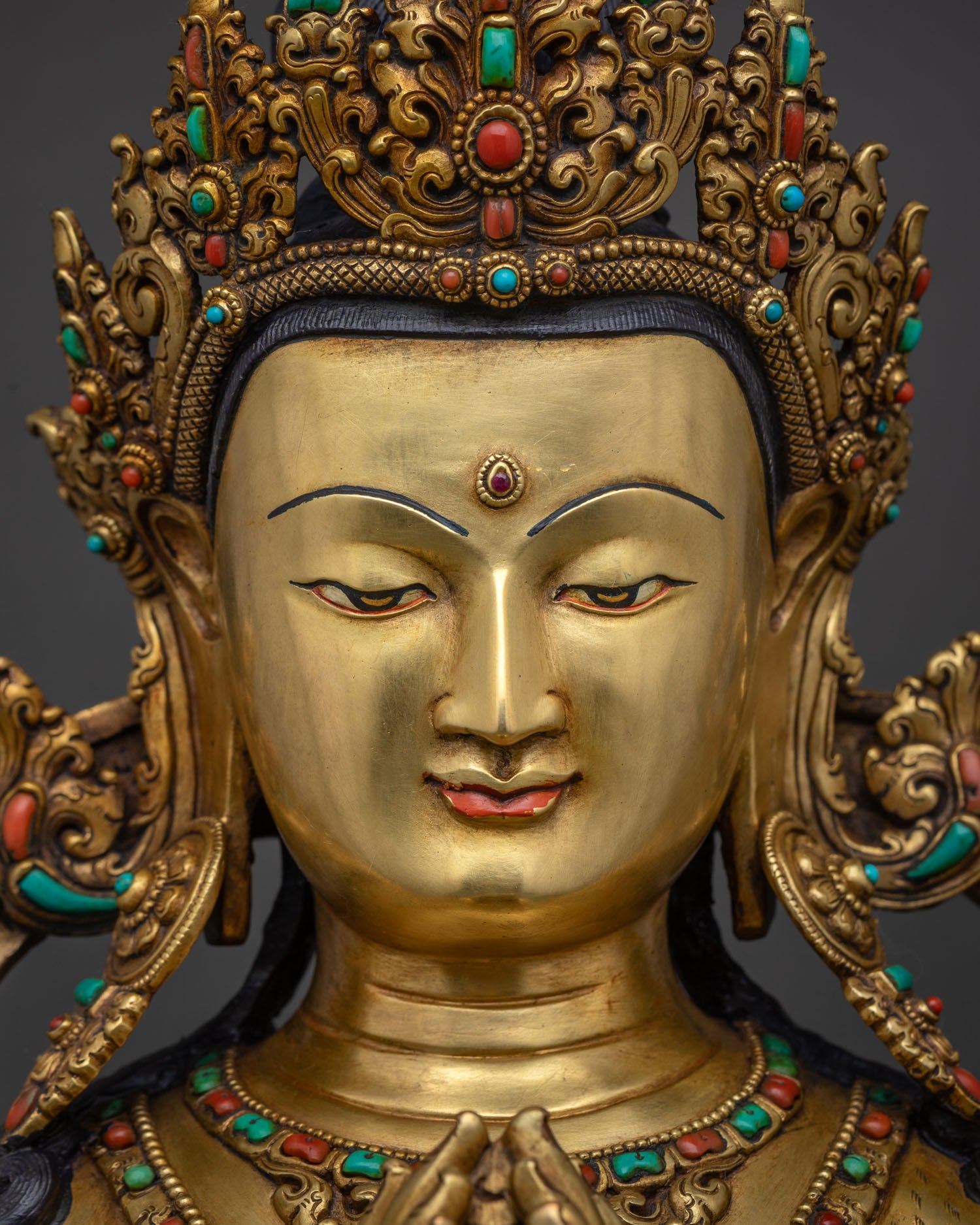 chenrezig statue face close up gold painted serene expression with jeweled crown patan nepal