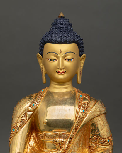 Close up view of Amitabha Buddha face showing gold painted serene expression with turquoise embellished monastic robe details